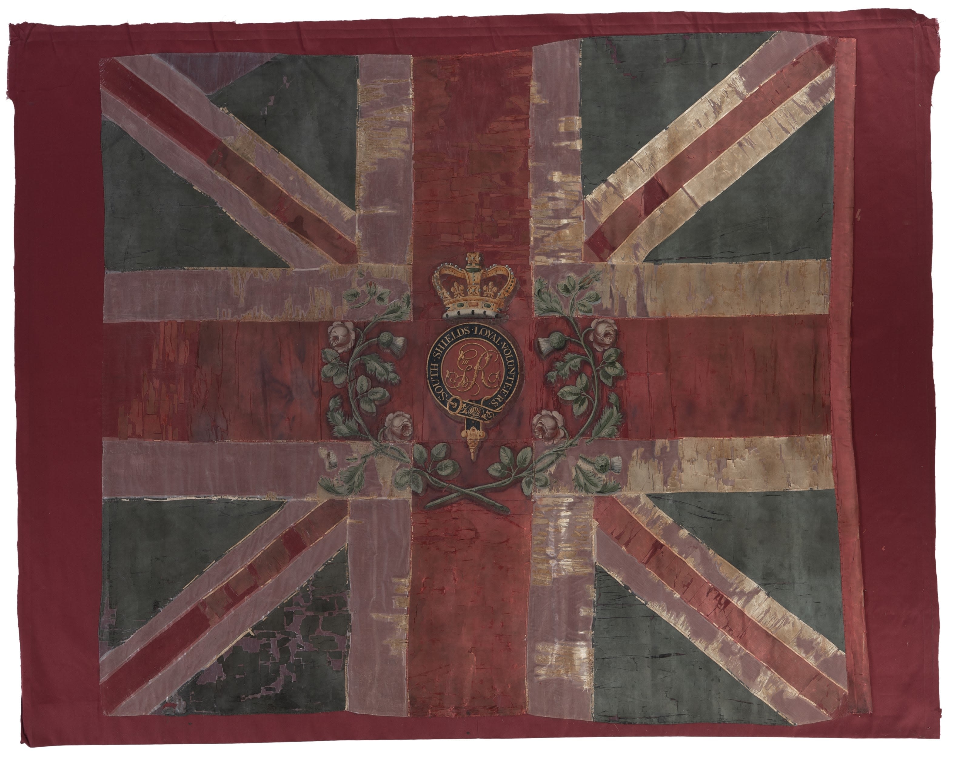 This Colour is a red, white and blue union flag with a central crest showing a green wreath, name of the unit and a crown.