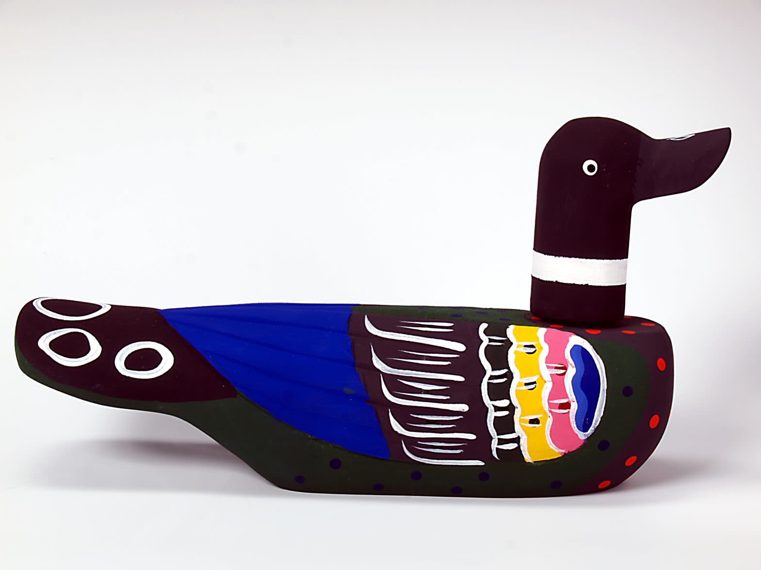 Black and blue painted wooden wedding duck. The duck's breast has red spots, the wing is blue with feathers painted pink, white and yellow