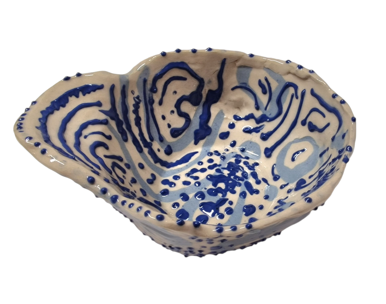 Above view of hump made stoneware bowl with abstract blue swirls and dots
