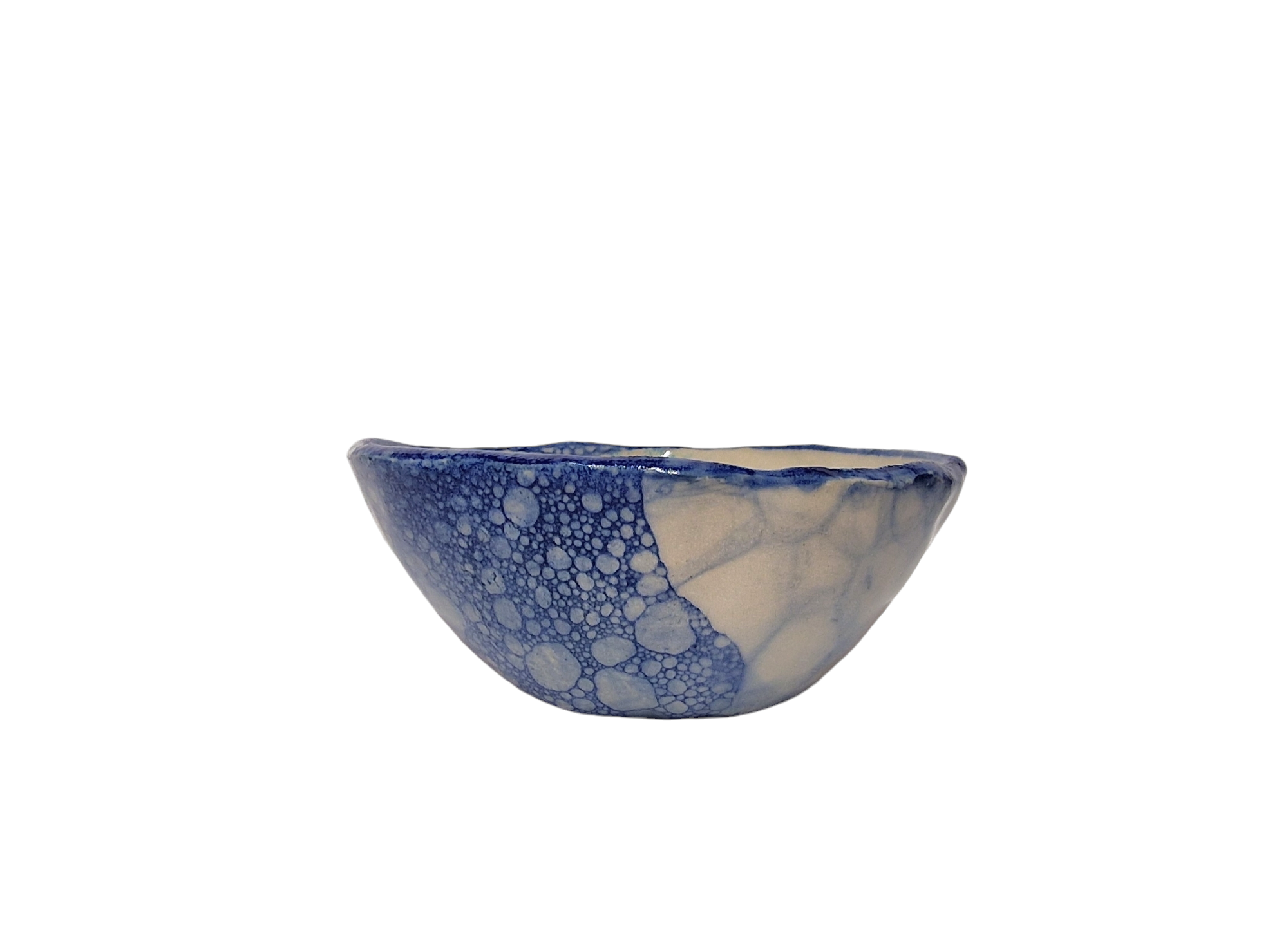 Side view of hump made stoneware bowl with blue bubble paint pattern