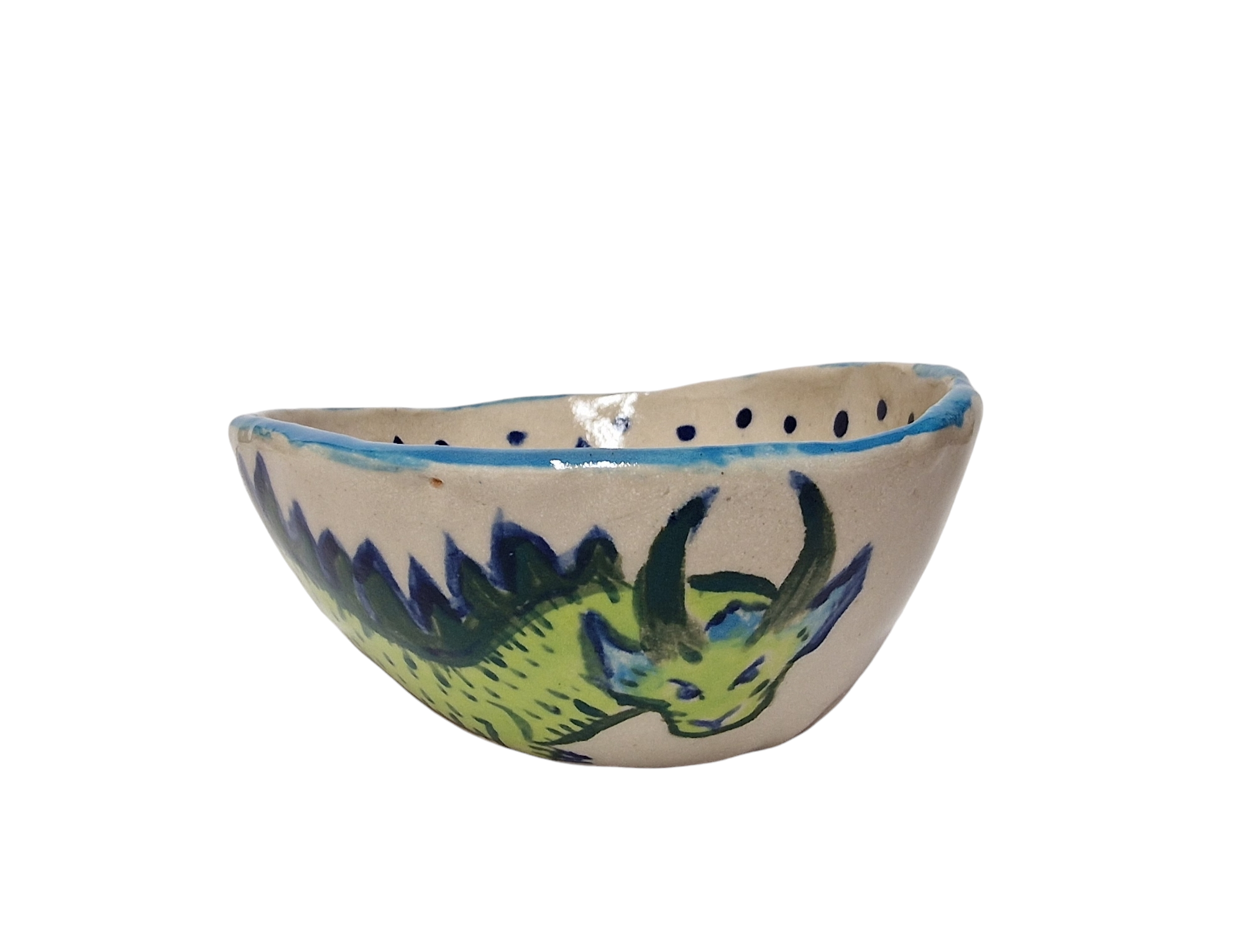Side view of hump made stoneware bowl with green and blue dragon like creature. Blue rim of bowl and hint of pattern inside bowl.