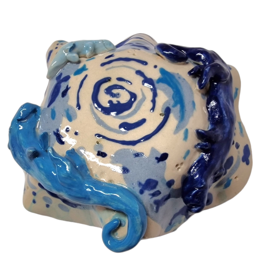 Above view of bottom of a hump made stoneware bowl with attached otter like creatures and painted blue fish
