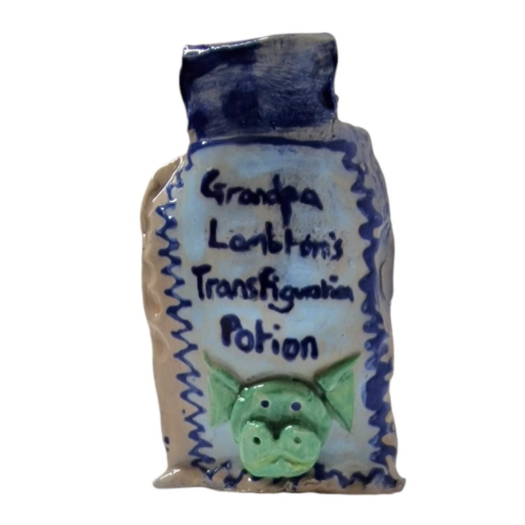 Hand built bottle with 3D dragon like face on body. With text that reads: Lambton's Transfiguration Potion