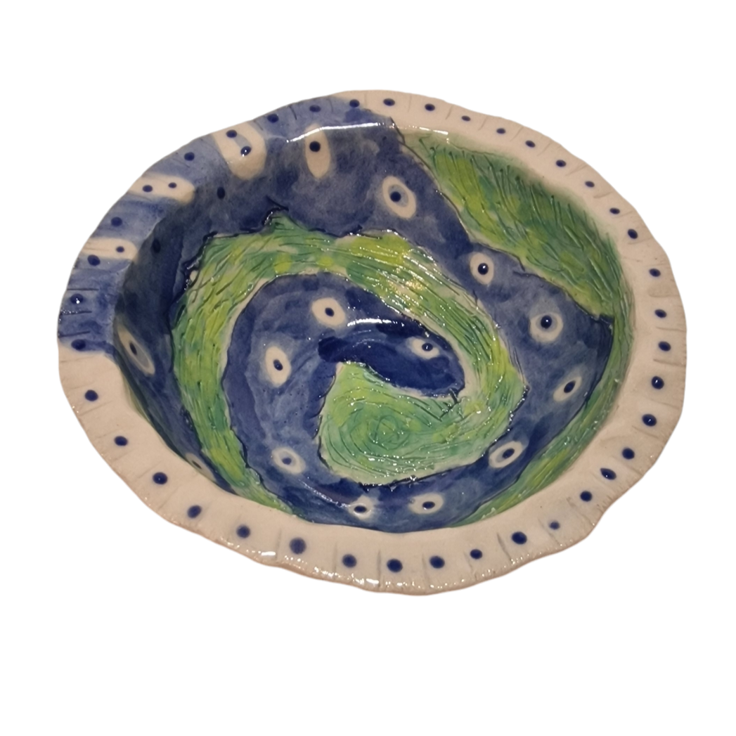 Above view of hump made stoneware bowl with abstract blue and green swirl in worm like fashion