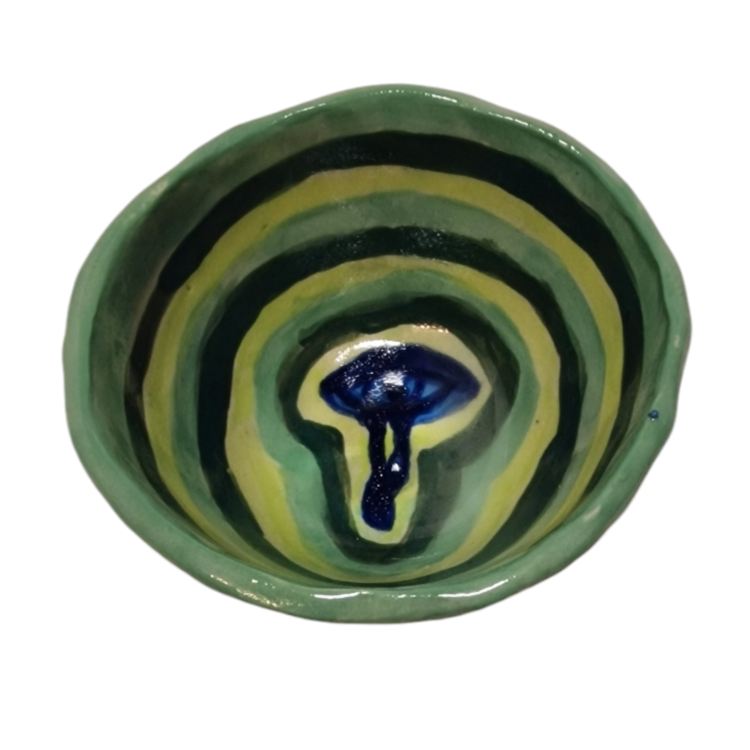 Above view of hump made stoneware bowl with blue eye in center with green and blue circles surrounding it