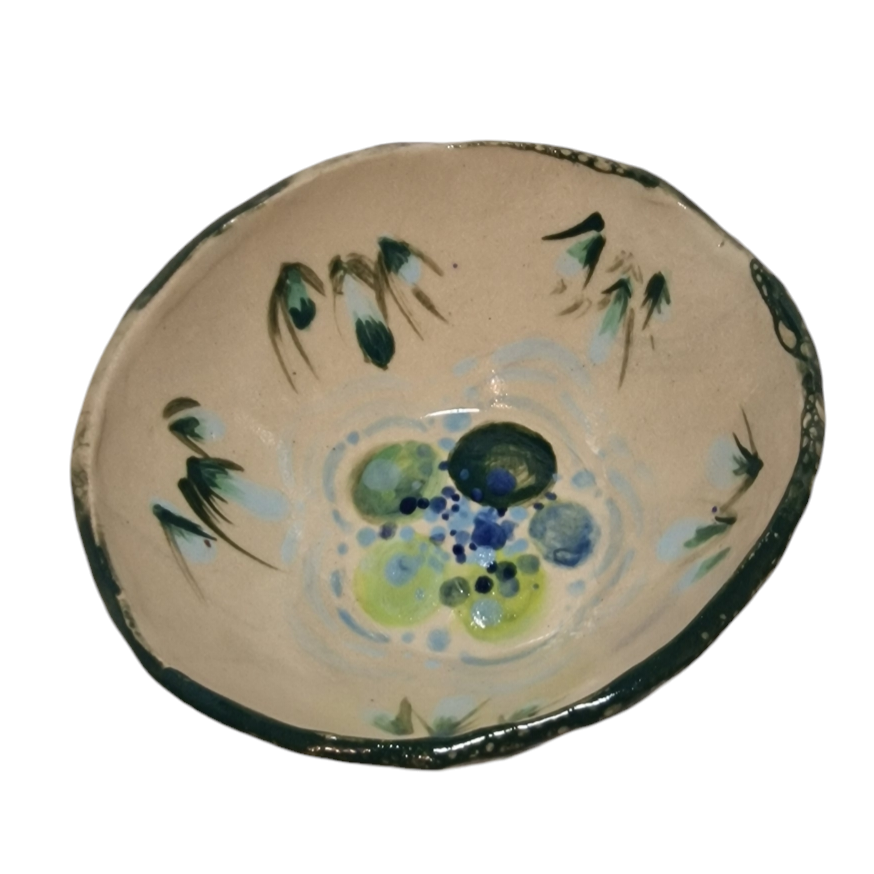 Above view of hump made stoneware bowl with green and blue illustration of water and reeds