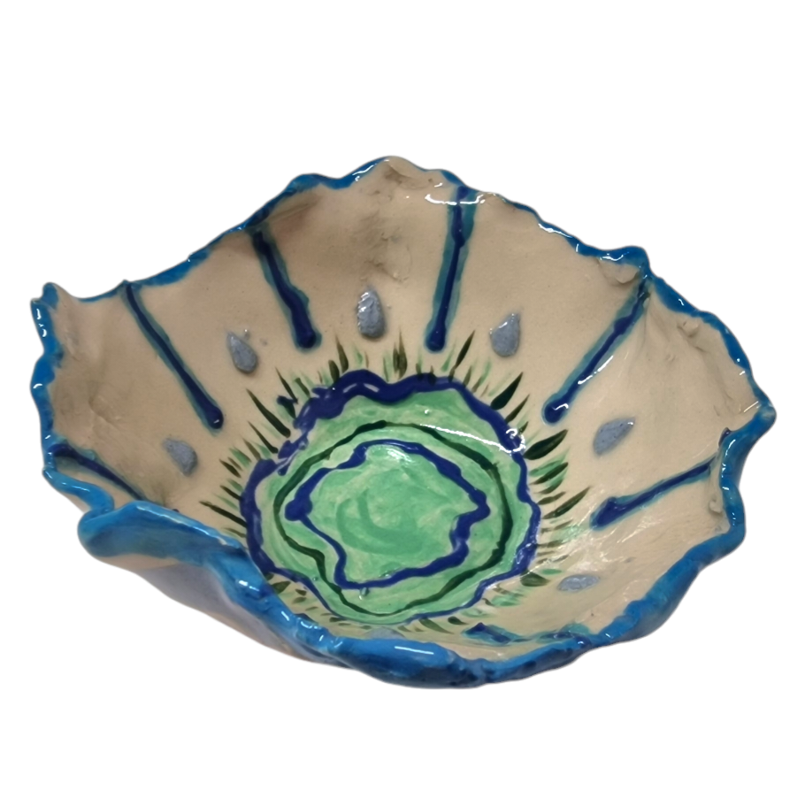 Above view of hump made stoneware bowl with abstract blue and green lines and shapes