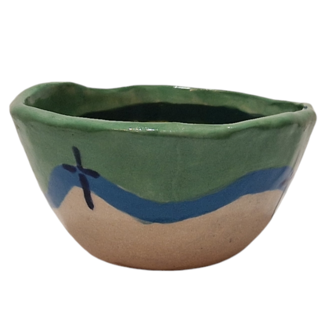 Side view of hump made stoneware bowl with blue and green wave pattern
