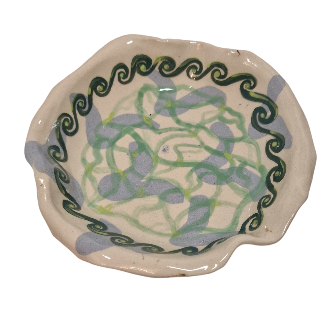 Above view of hump made stoneware bowl with abstract celtic style blue and green shapes
