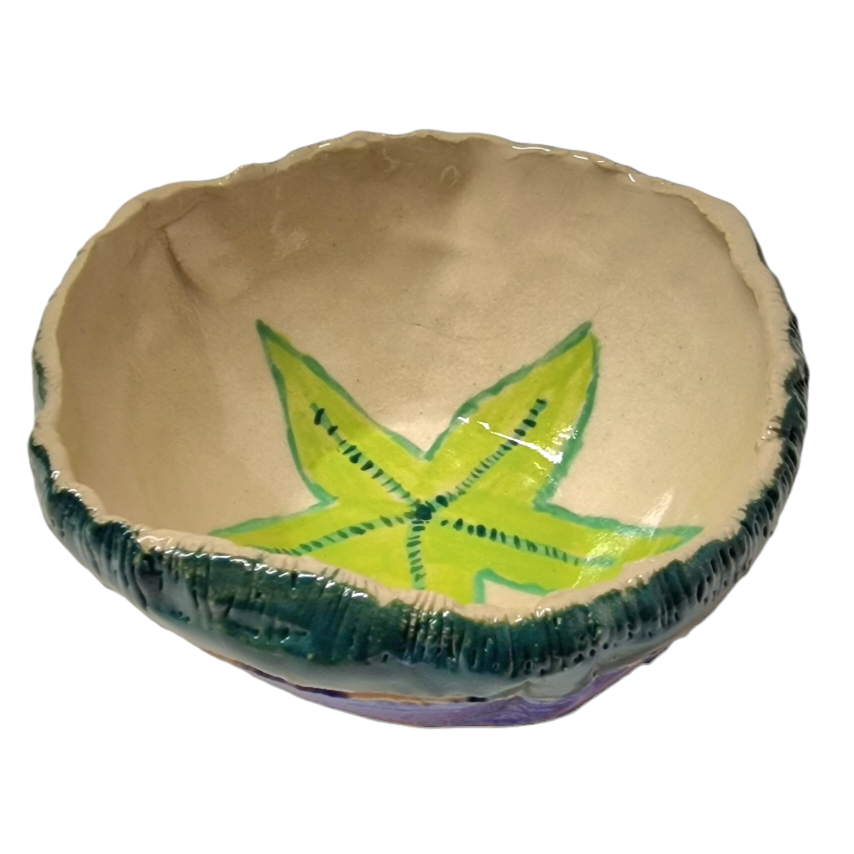 Above view of hump made stoneware bowl with green leaf like shape in center