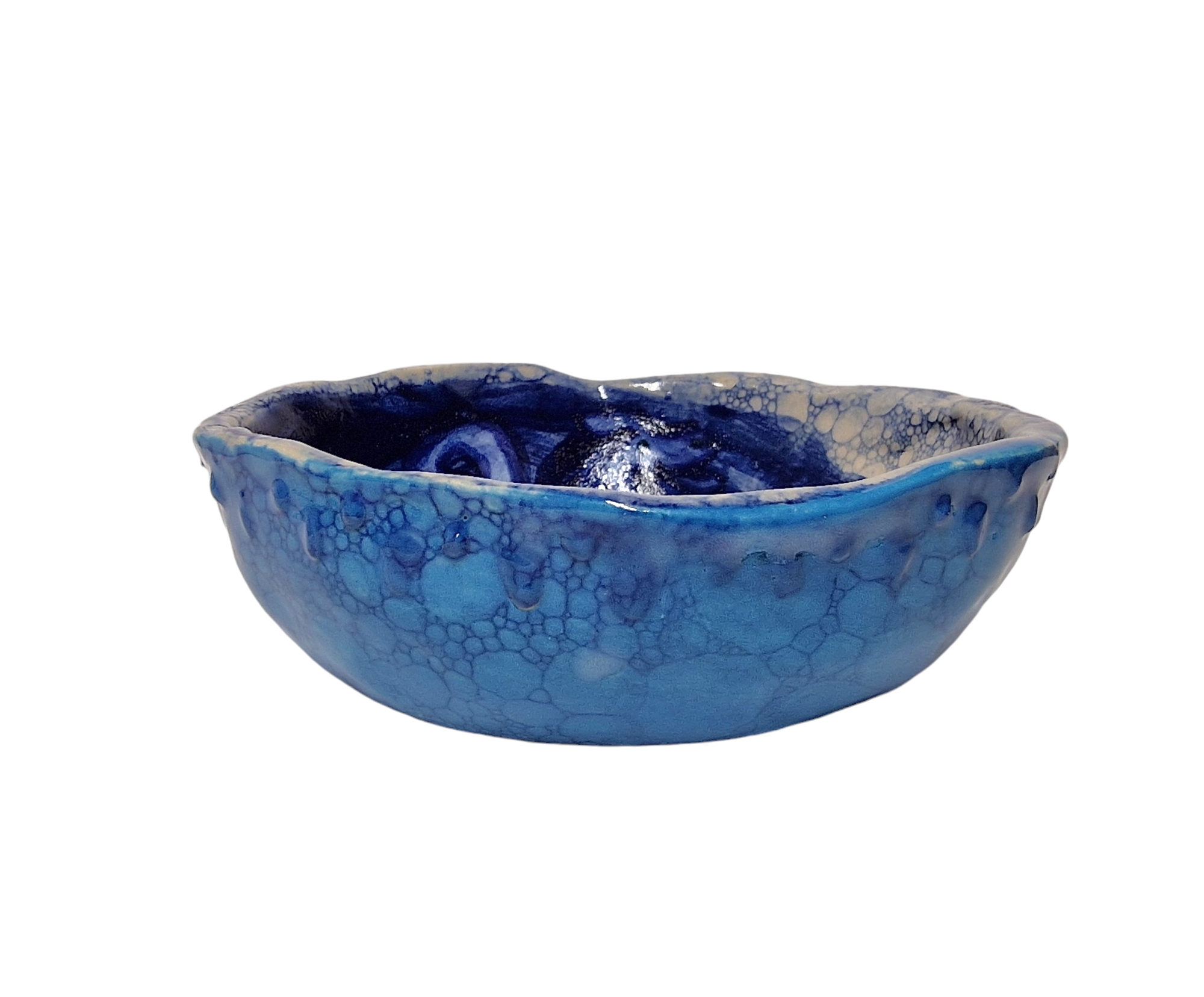 Side view of hump made stoneware bowl with blue bubble paint pattern