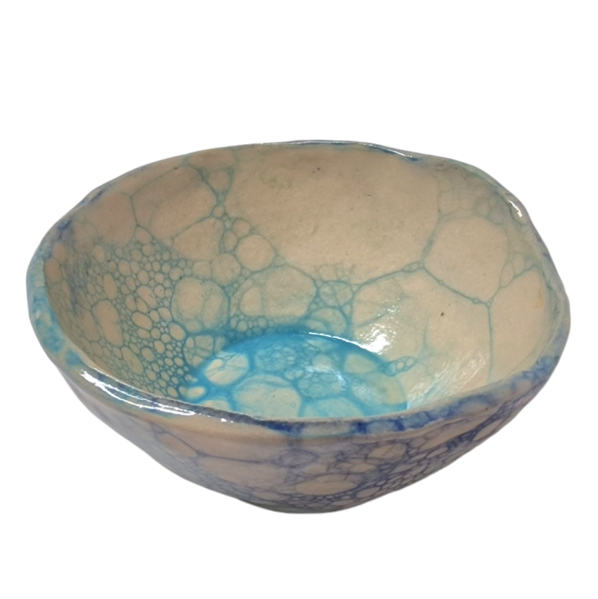 Above view of hump made stoneware bowl with blue bubble pattern on inside of bowl