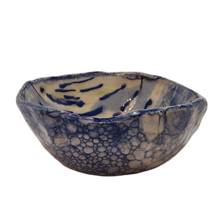 Side view of hump made stoneware bowl with blue bubble paint pattern