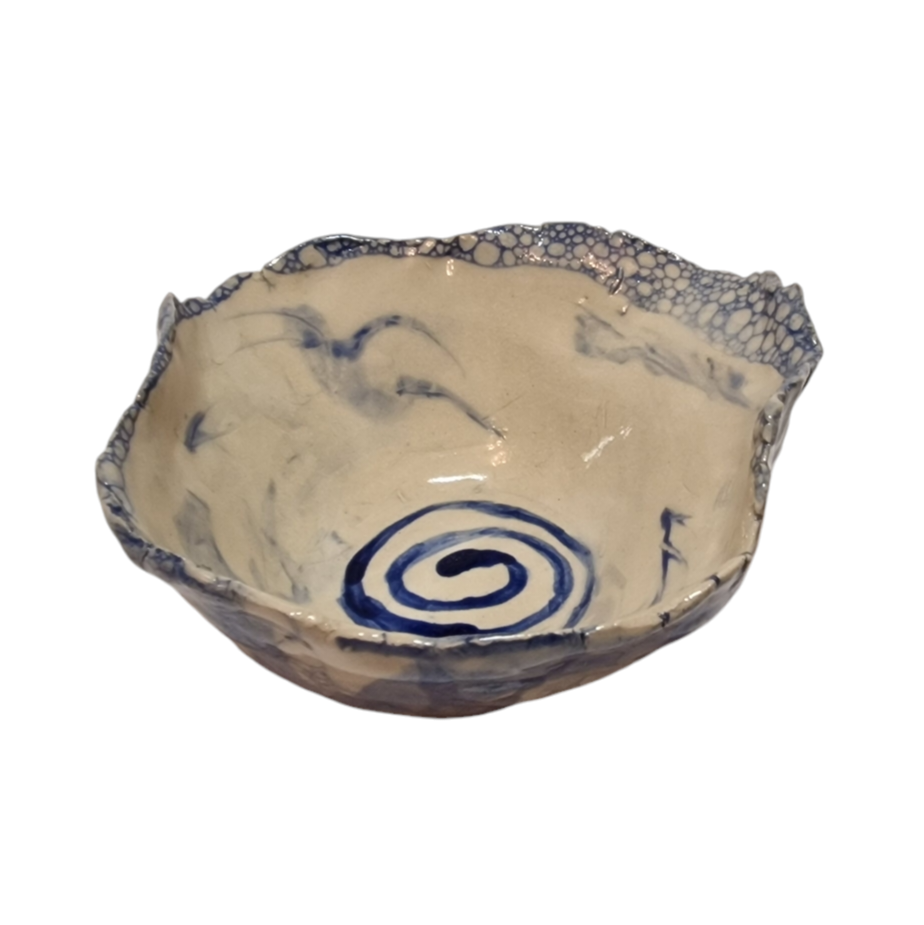 Above view of hump made stoneware bowl with blue swirl painting in the center of the bowl