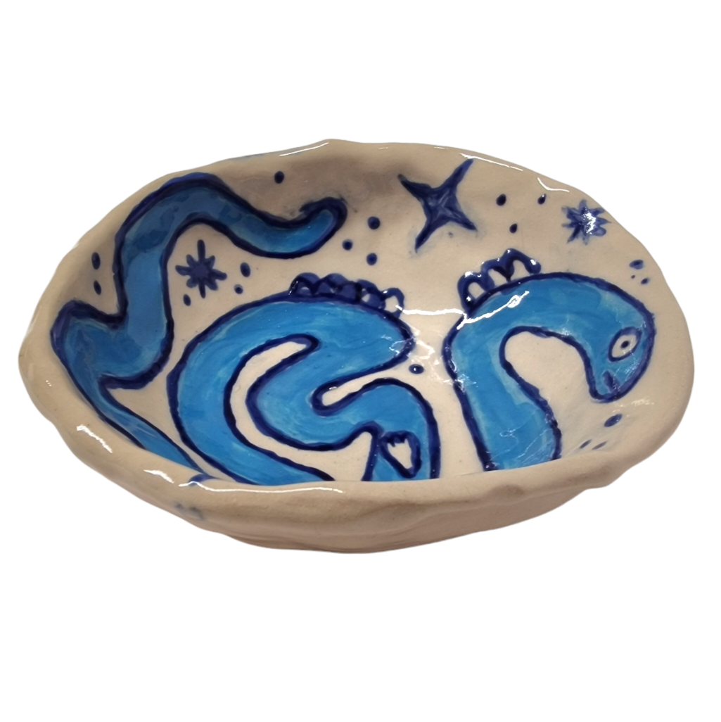 Above view of hump made stoneware bowl with illustration of blue worm like creature