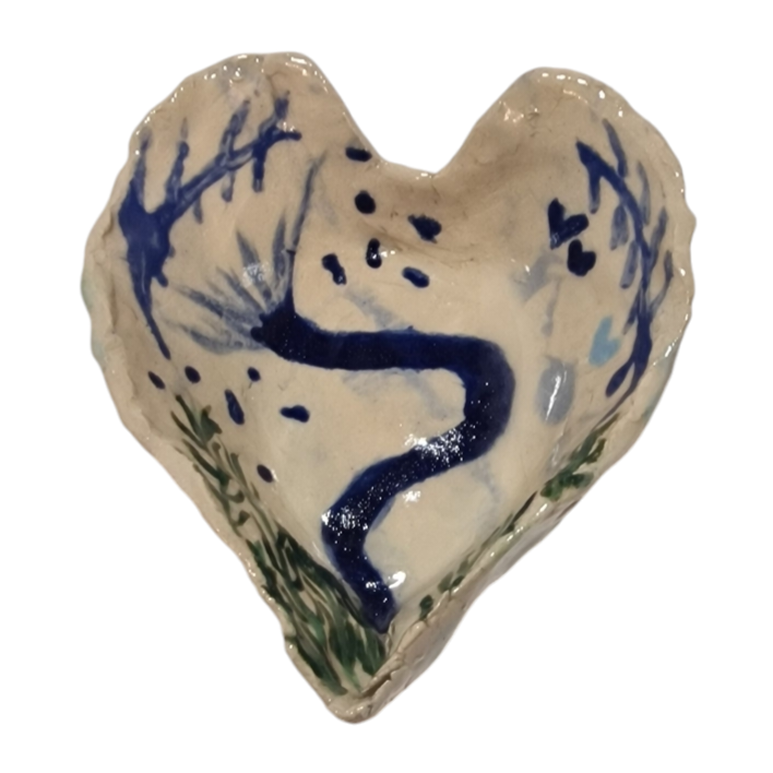 Above view of heart shaped stoneware bowl with abstract blue shapes