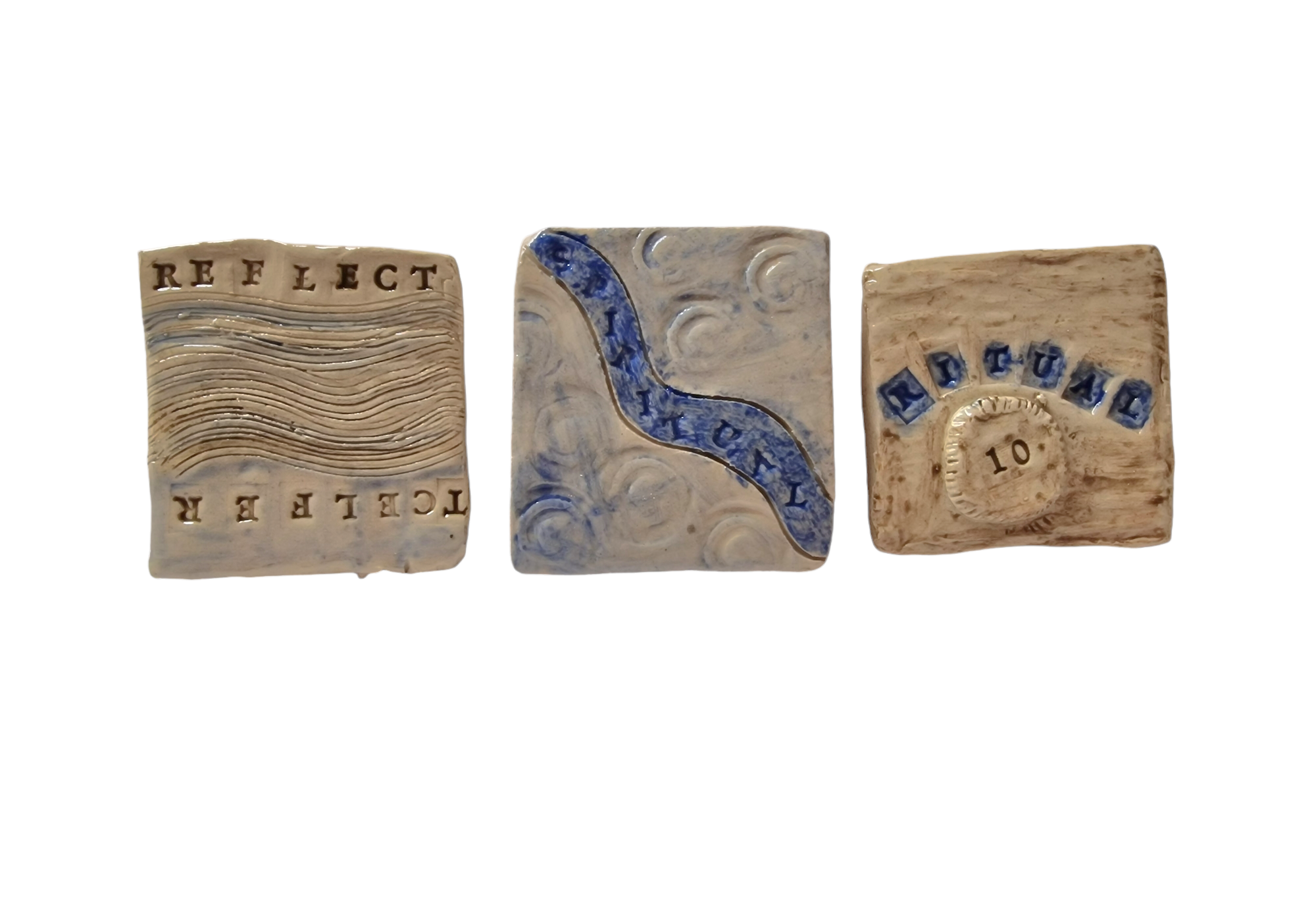 Three square tiles with abstract markings and text reading: reflect, spirituality and ritual