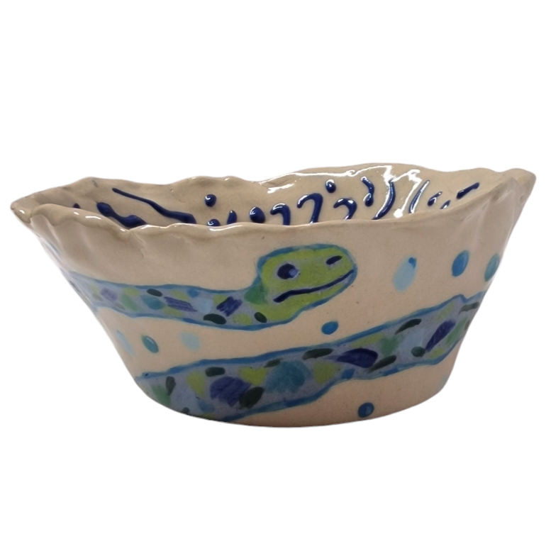 Side view of hump made stoneware bowl with worm figure illustration in blue and green