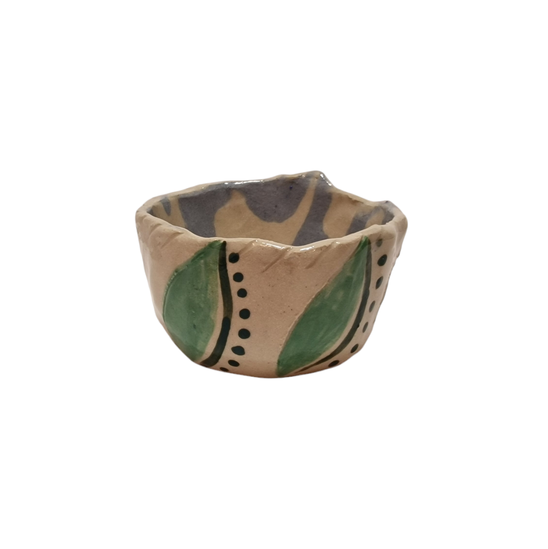 Side view of hump made stoneware bowl with abstract shapes including leaf like shapes and dots in greens and blues