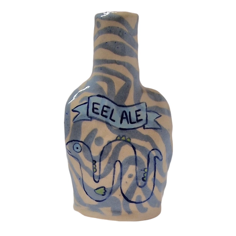 Hand built bottle with blue pattern. On the bottle reads: EEL ALE in a ribbon banner and an eel is painted under this