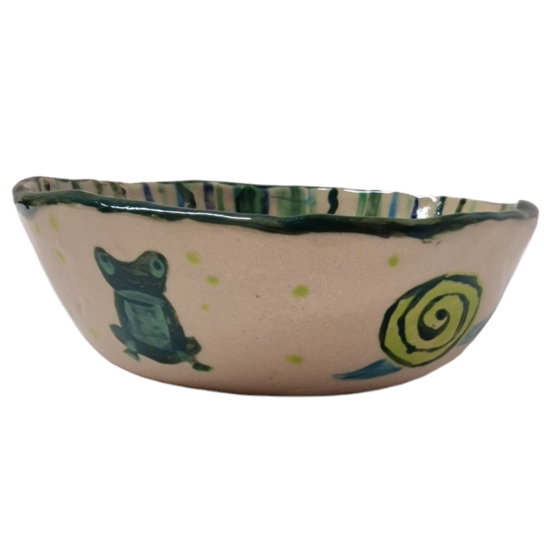 Side view of hump made stoneware bowl with frog and snail illustration