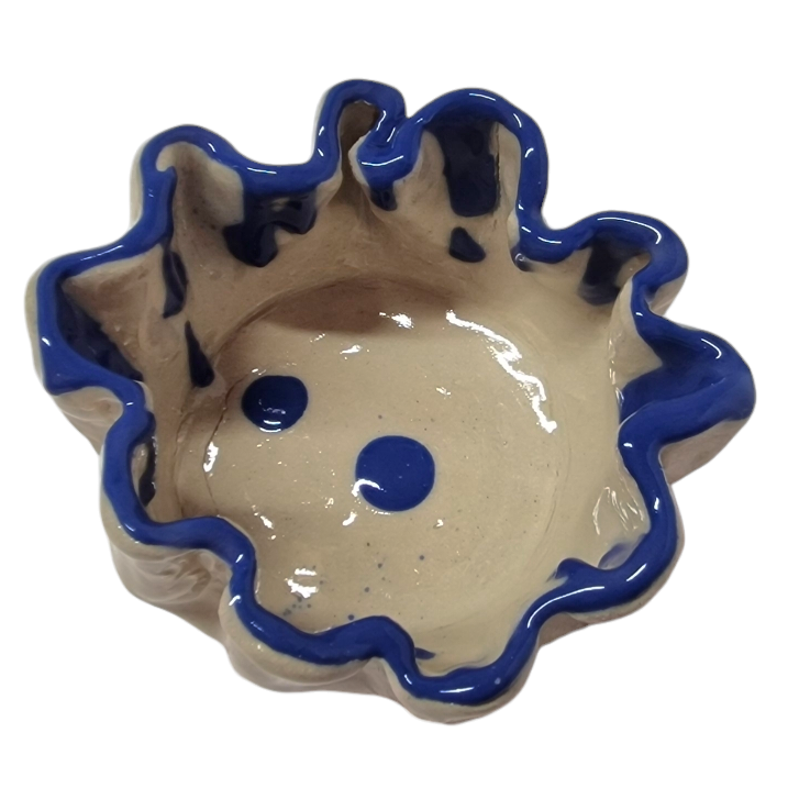 Above view of hump made stoneware bowl with dark blue wavey rim