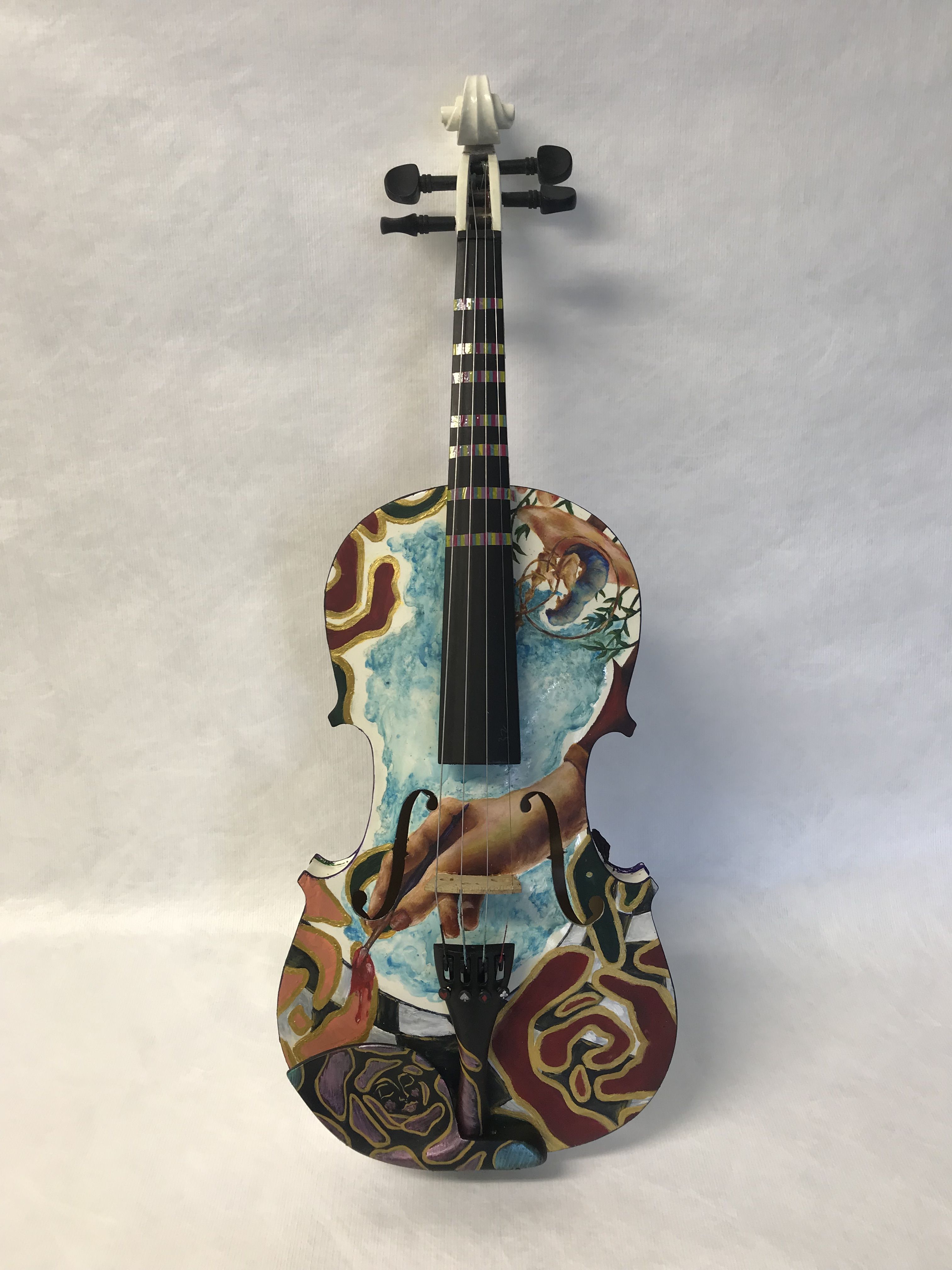 Photo of a painted violin. The violin is decorated with a hand painting roses red.