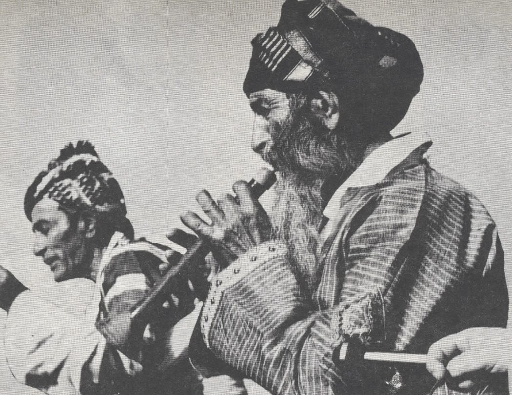 Black and white photograph of man playing an instrument.