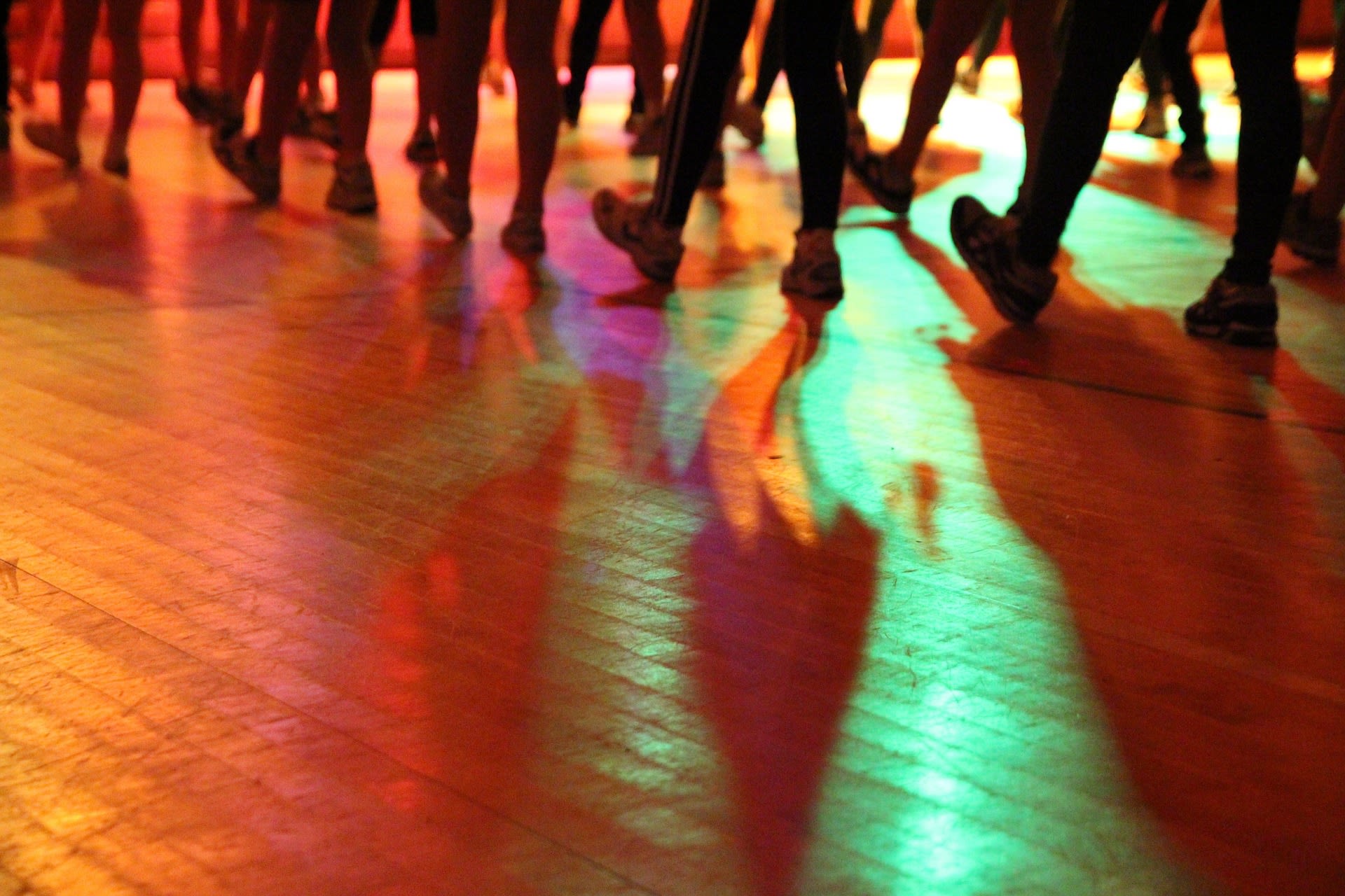 A group of people tap their feet on the dancefloor