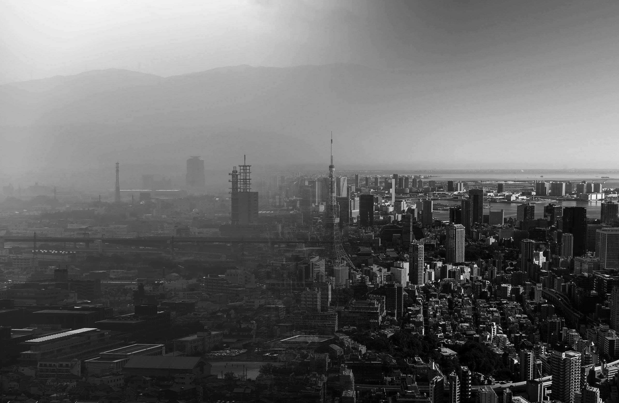 Aerial view of the city of Tokyo - the left hand side covered in thick smog, the right hand side with clear skies