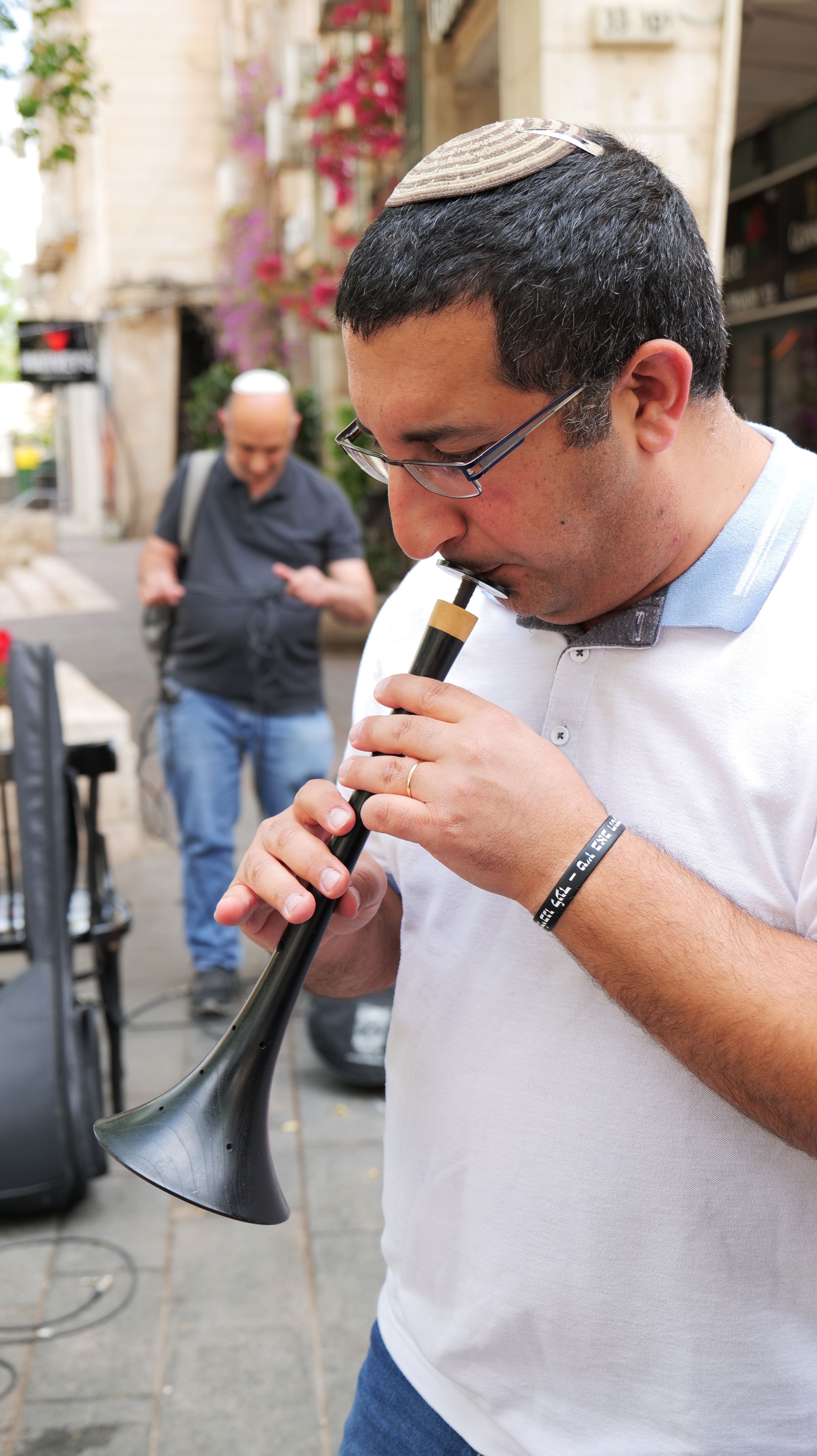 Colour photograph, outdoors, of men playing musical instruments in the street.