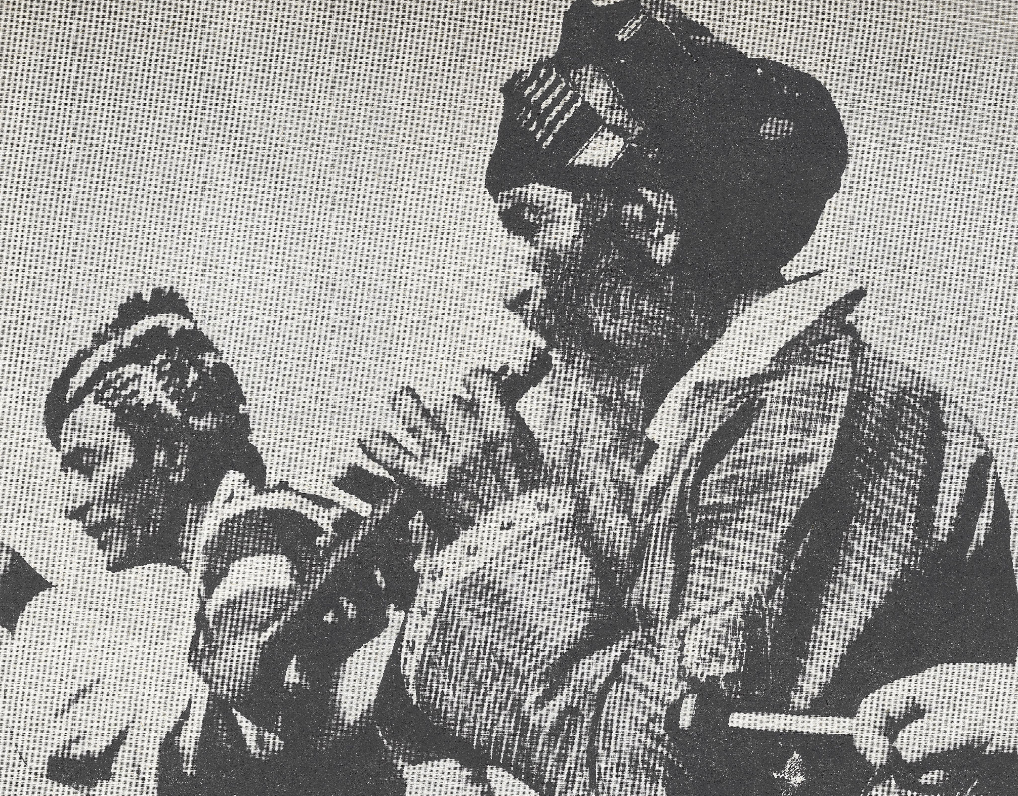 Black and white photograph of man playing an instrument.