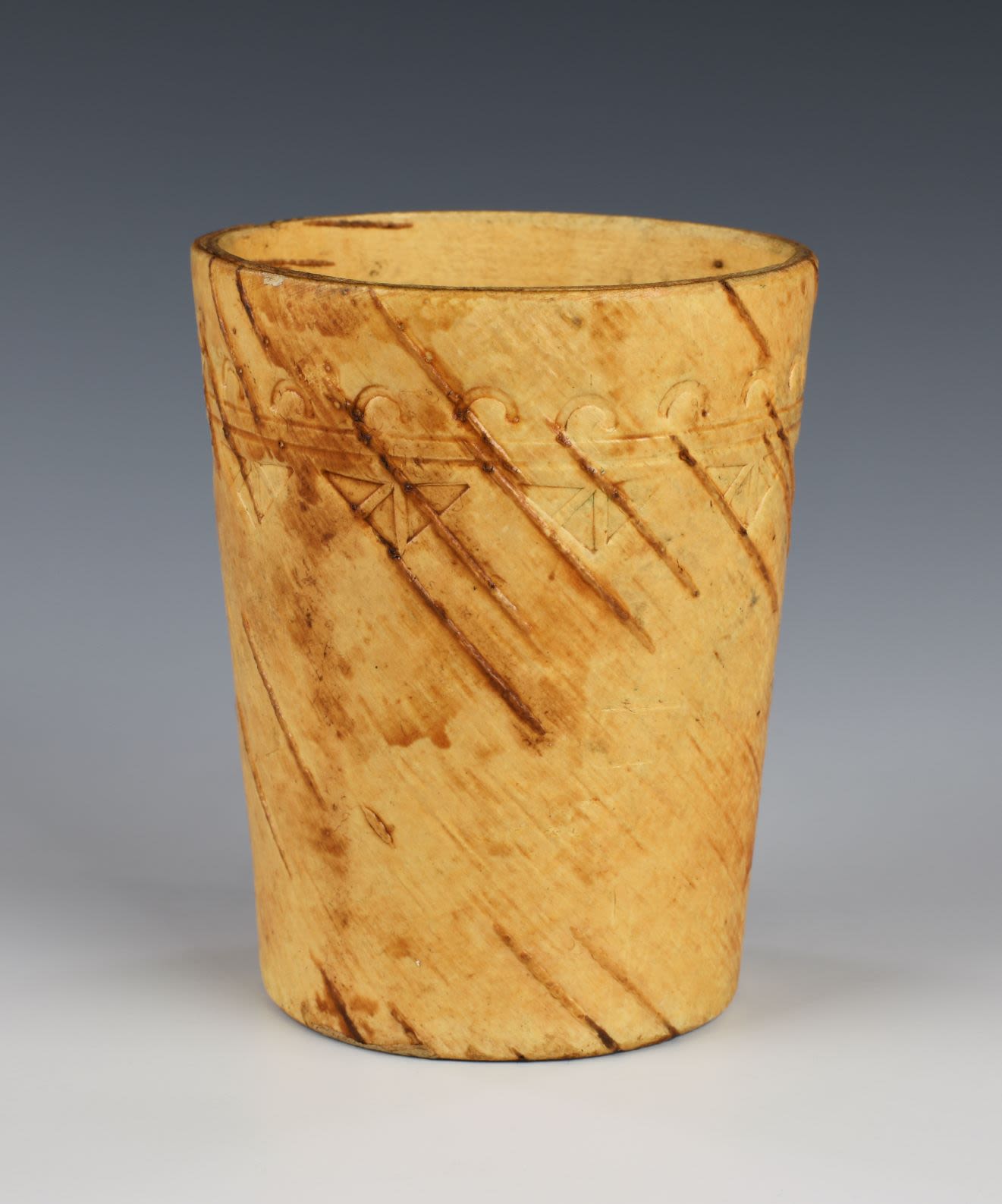 Birch wood container with decorations around the top.