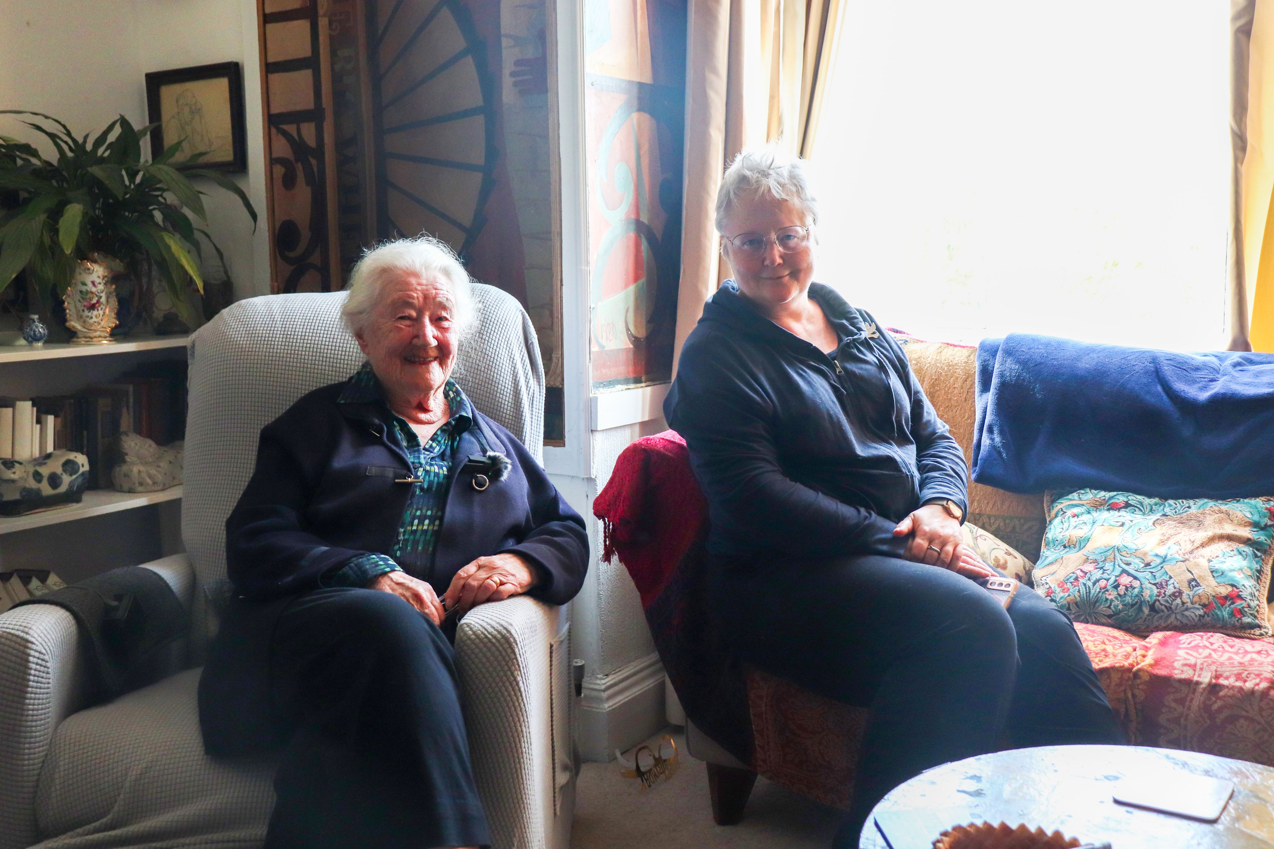 Photograph of two women sitting on chairs.
