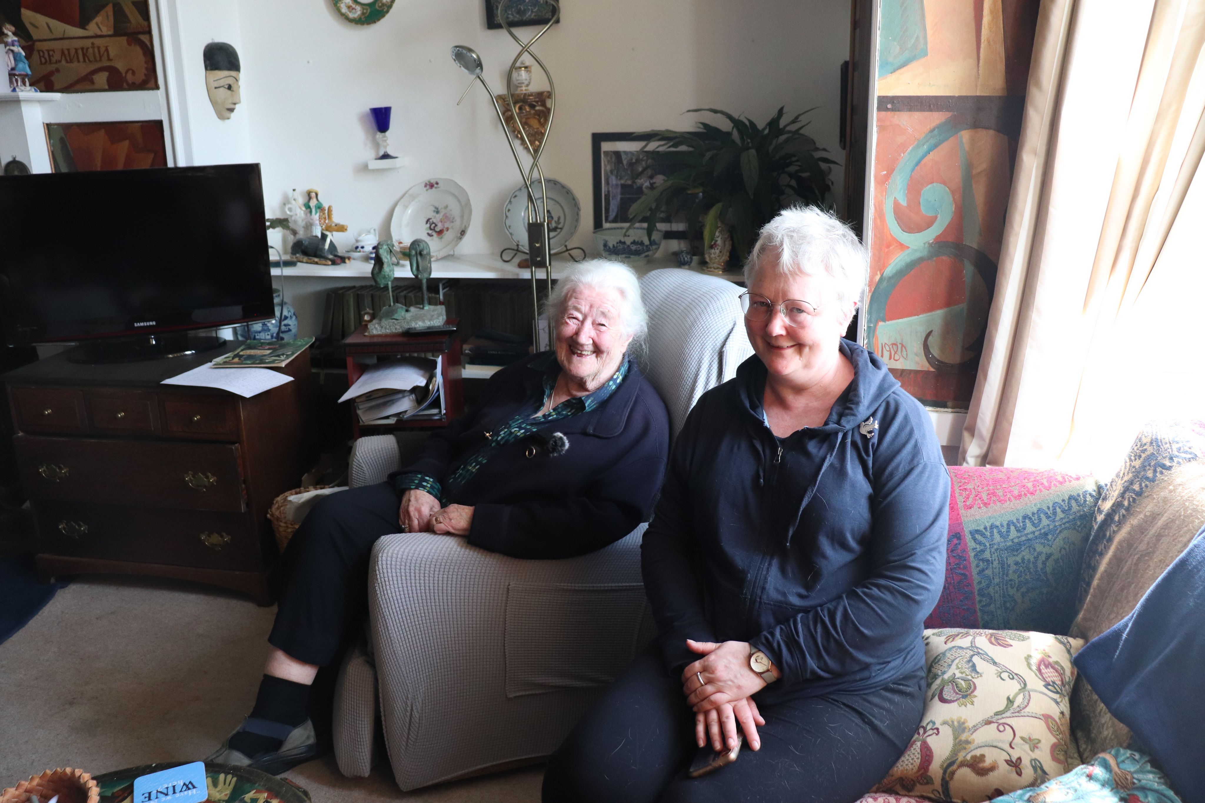 Photograph of two women sitting on chairs.