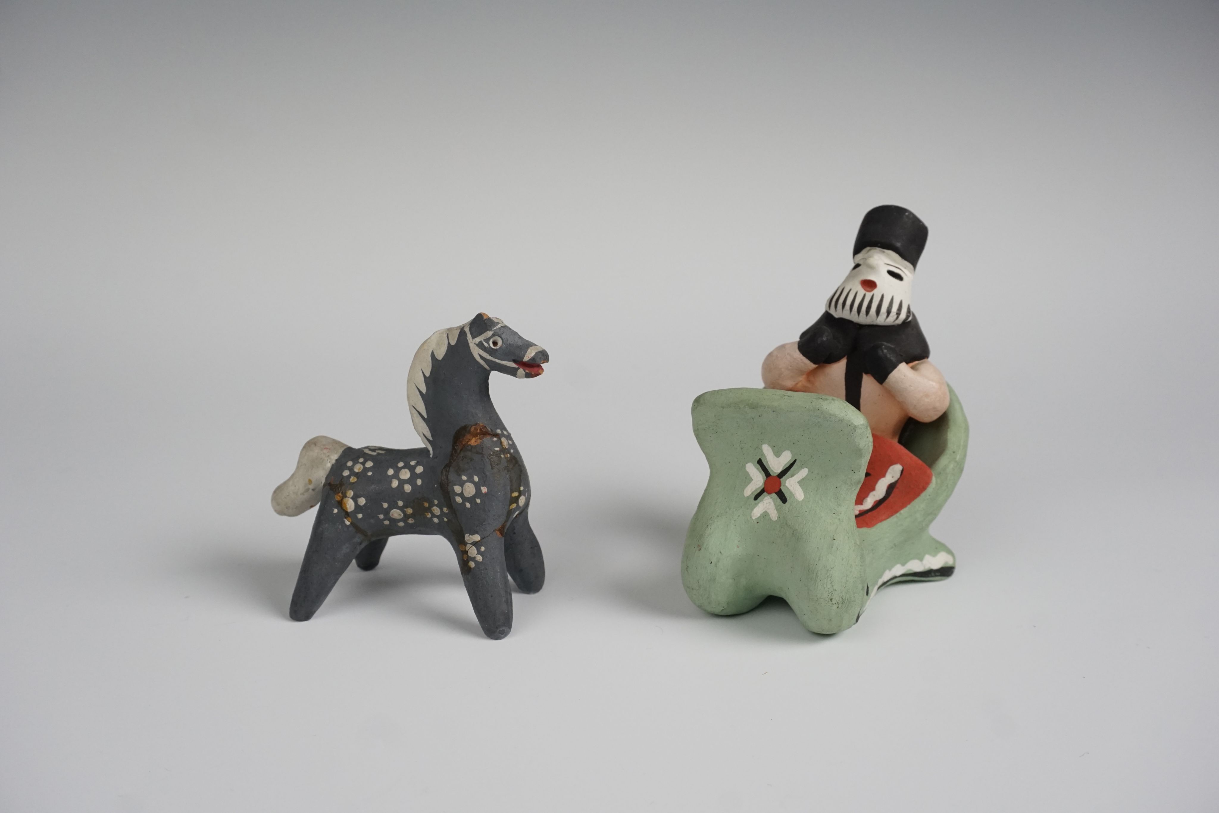 Clay toys: a grey horse and a bearded man in a green sleigh