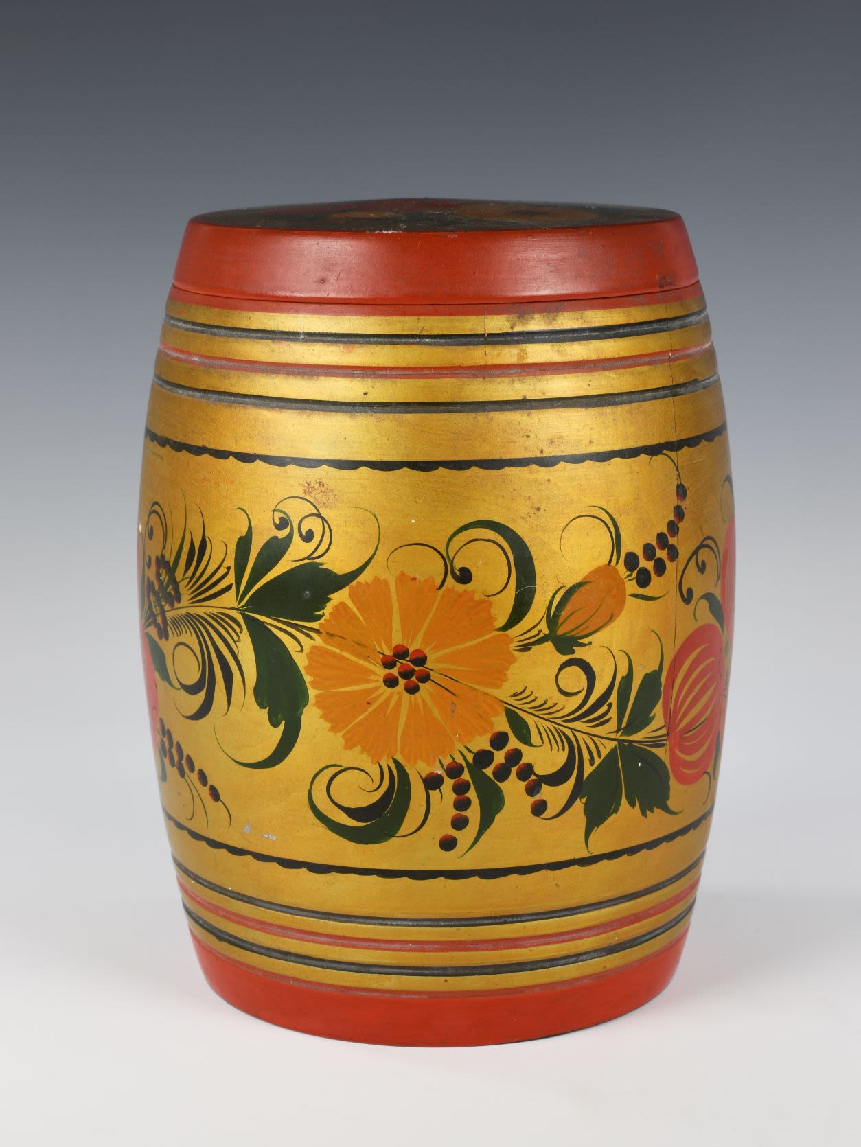 Khokhloma jar with a lid. with thin stripe pattern of red, black and gold. Wide central part decorated with floral pattern depicting a cluster of red rounded berries or fruits, green leaves and yellow flowers with elements of green grass on a gold background.