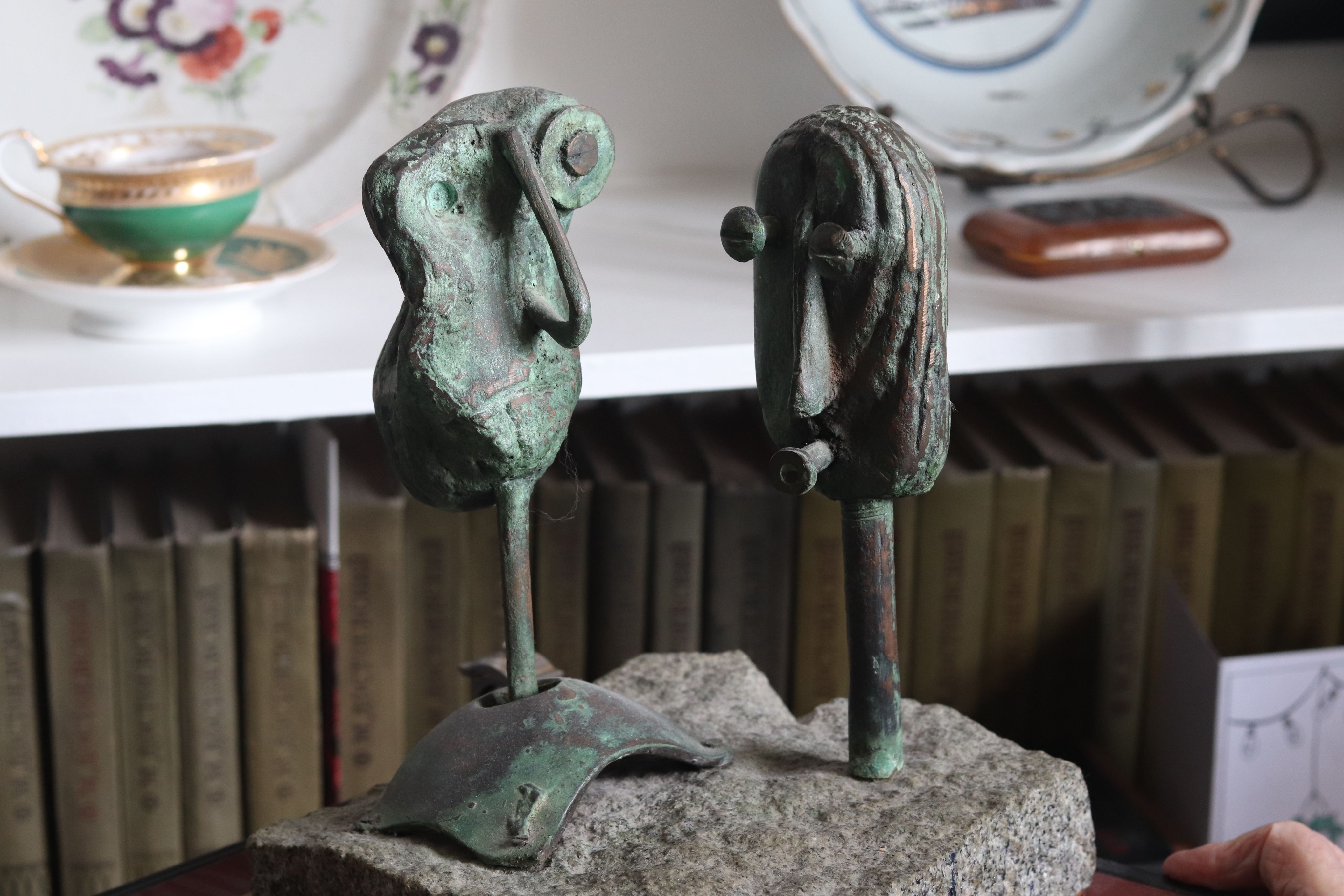 Green scuplture of face made from different materials