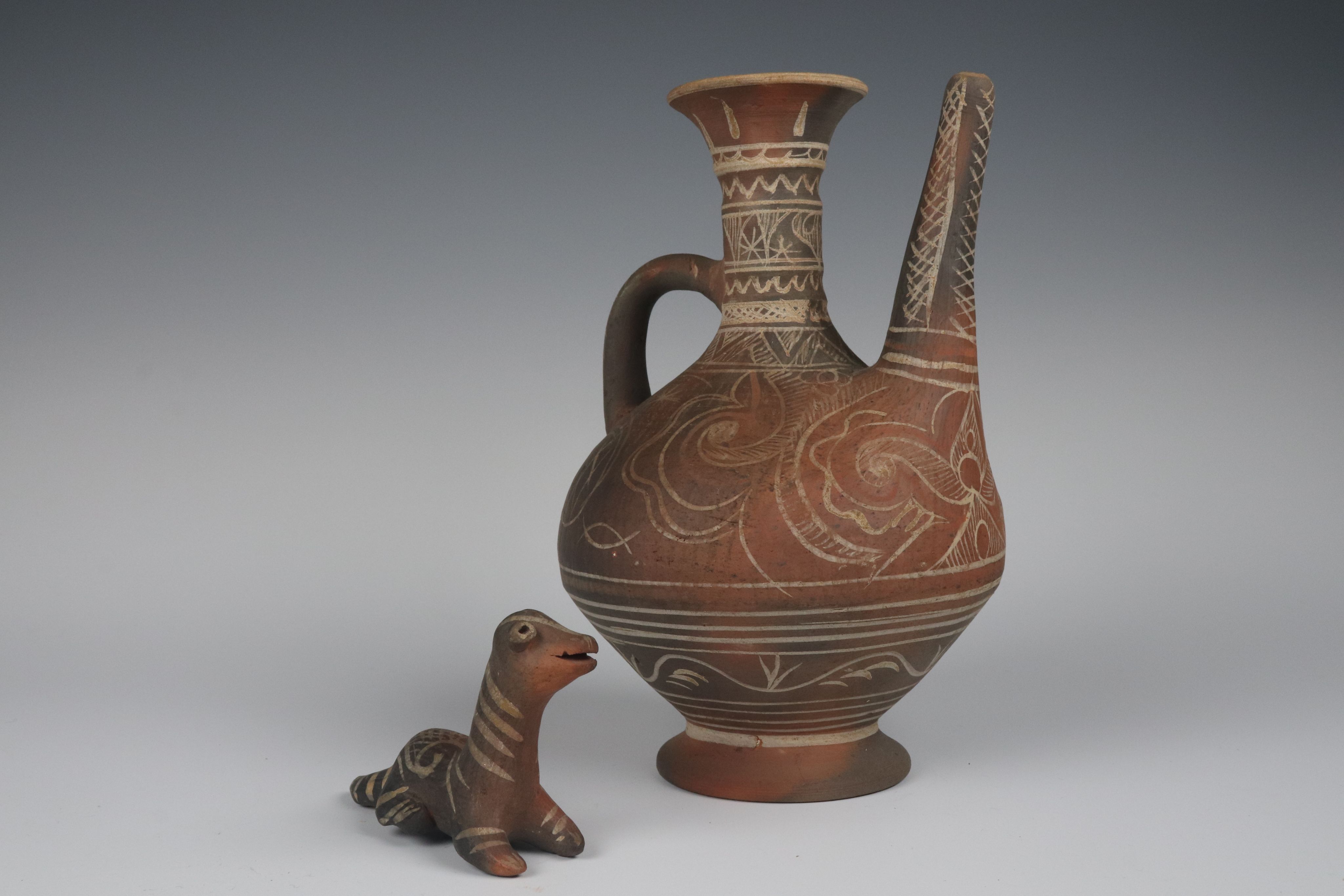 lying ceramic creature and jar both decorated with geometric motifs