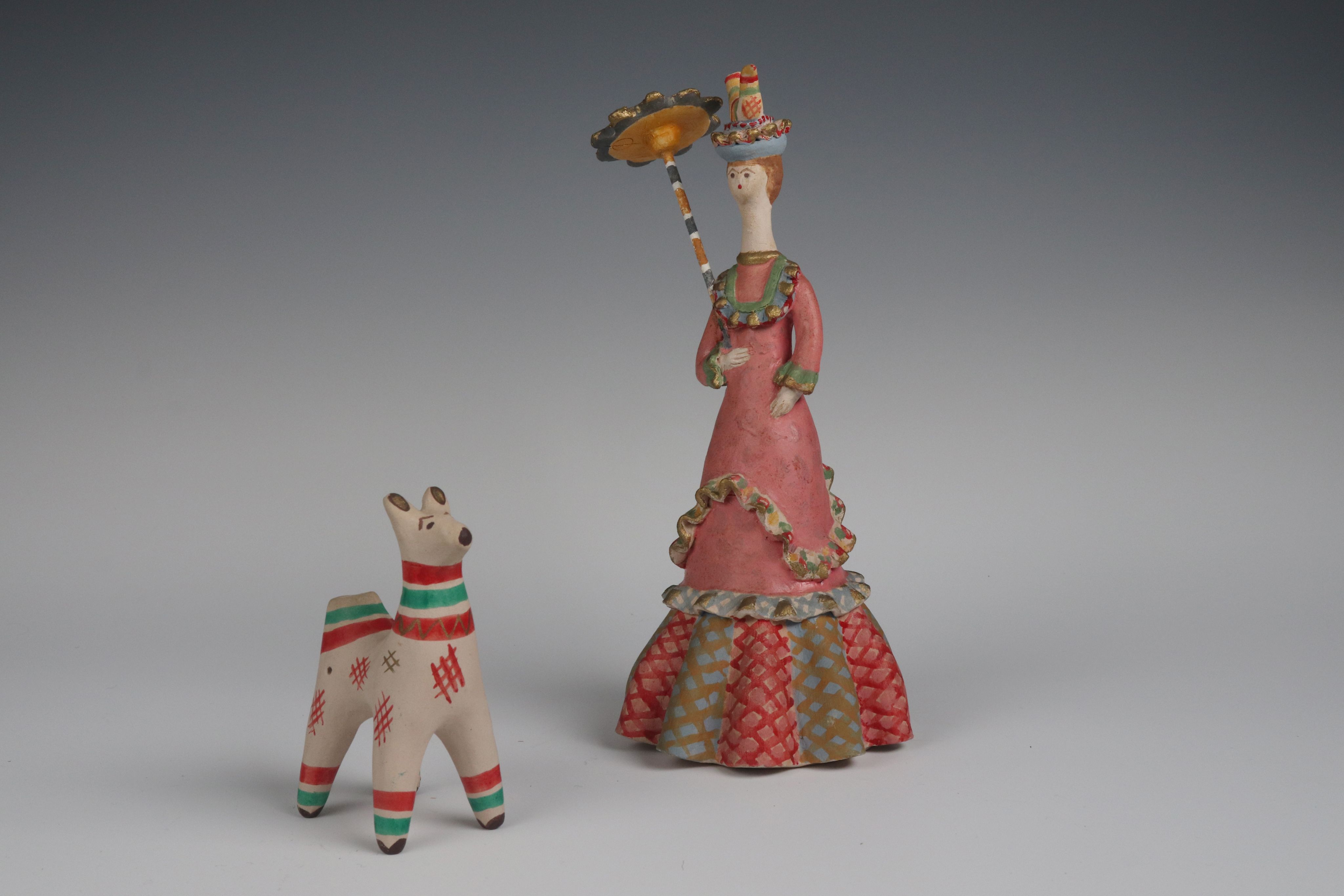 clay toys: white dog with stripes and a lady in a pink dress with a parasol and hat with a bird on it.
