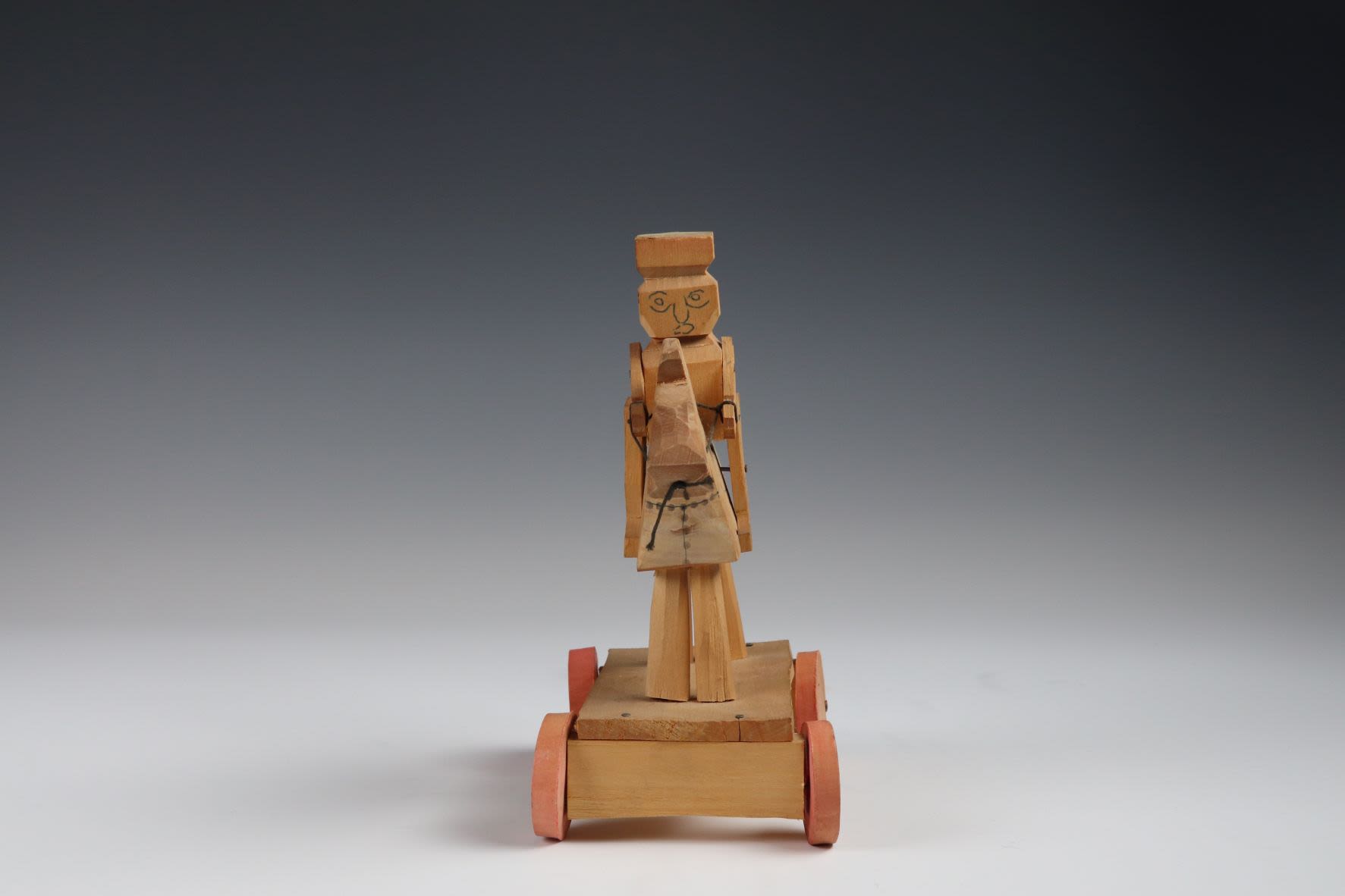 Wooden horse and rider on painted red wheels.