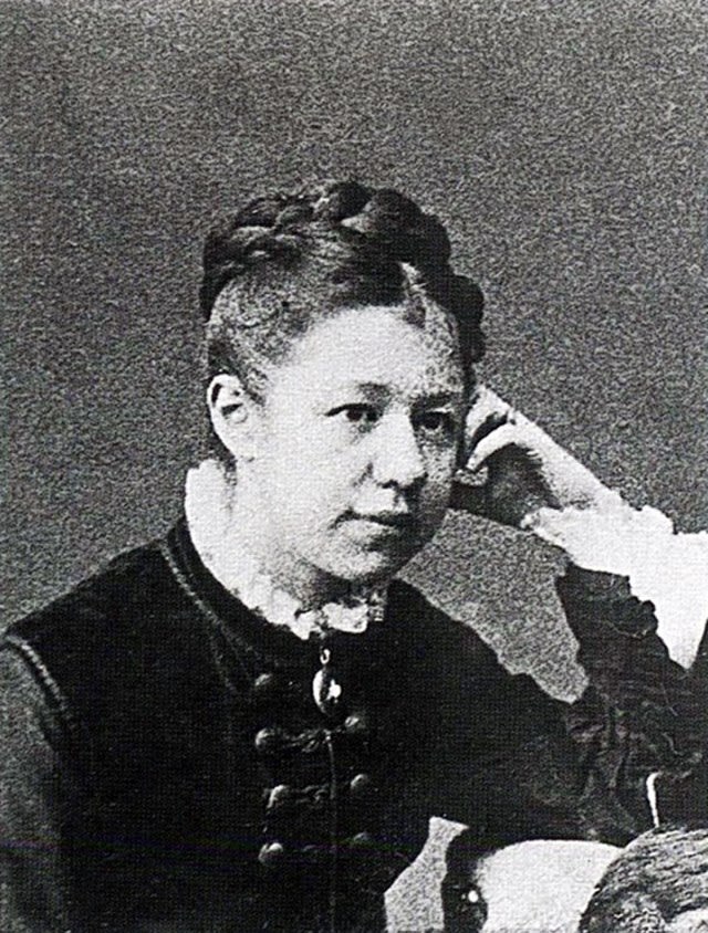 a young woman wearing traditional Edwardian clothing, with her hair tightly fasten to her headfrom the
