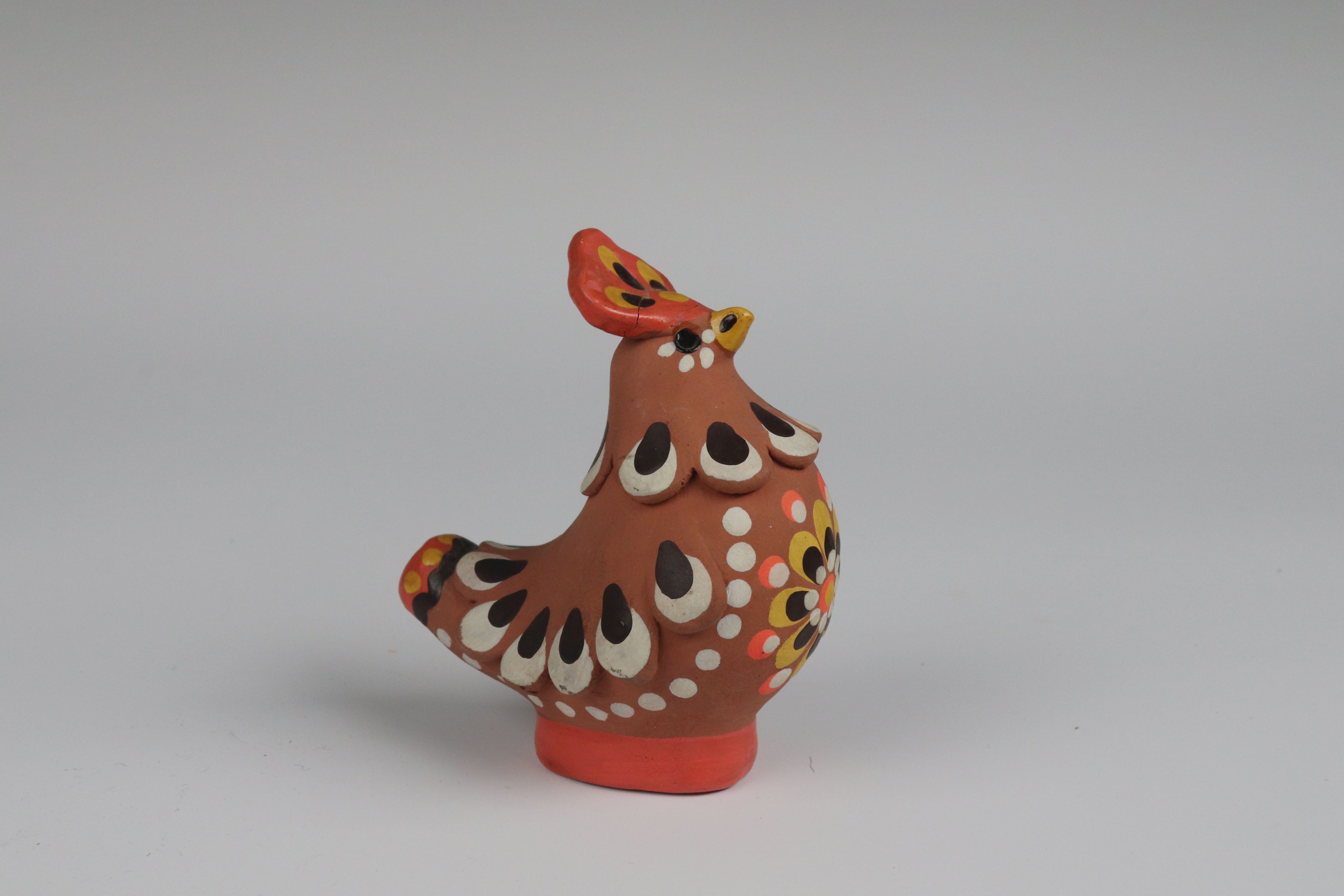 a brown clay bird whistle with brown, yellow, orange and white decorations