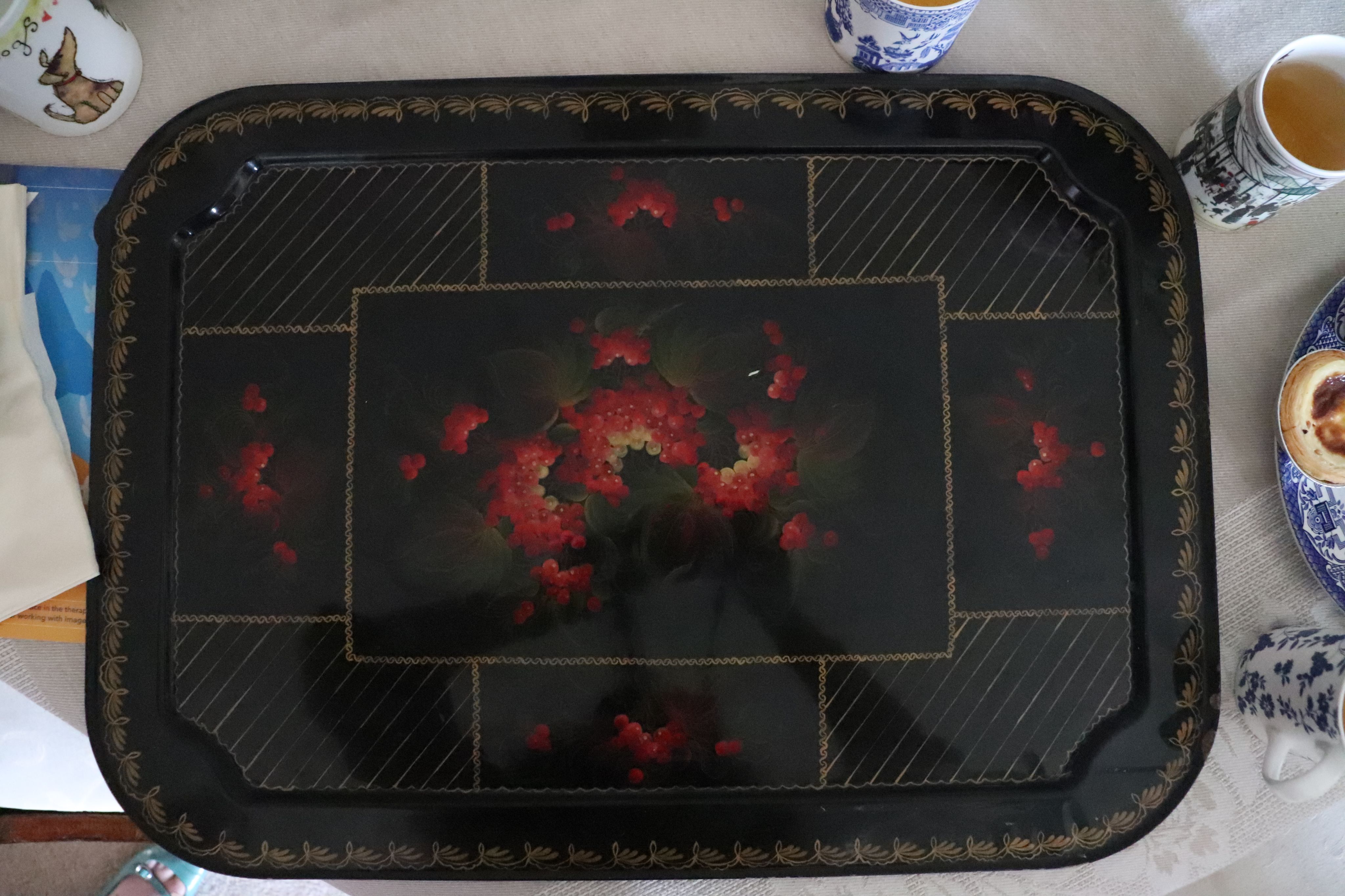 Photograph of a black tray with red flower pattern on it.