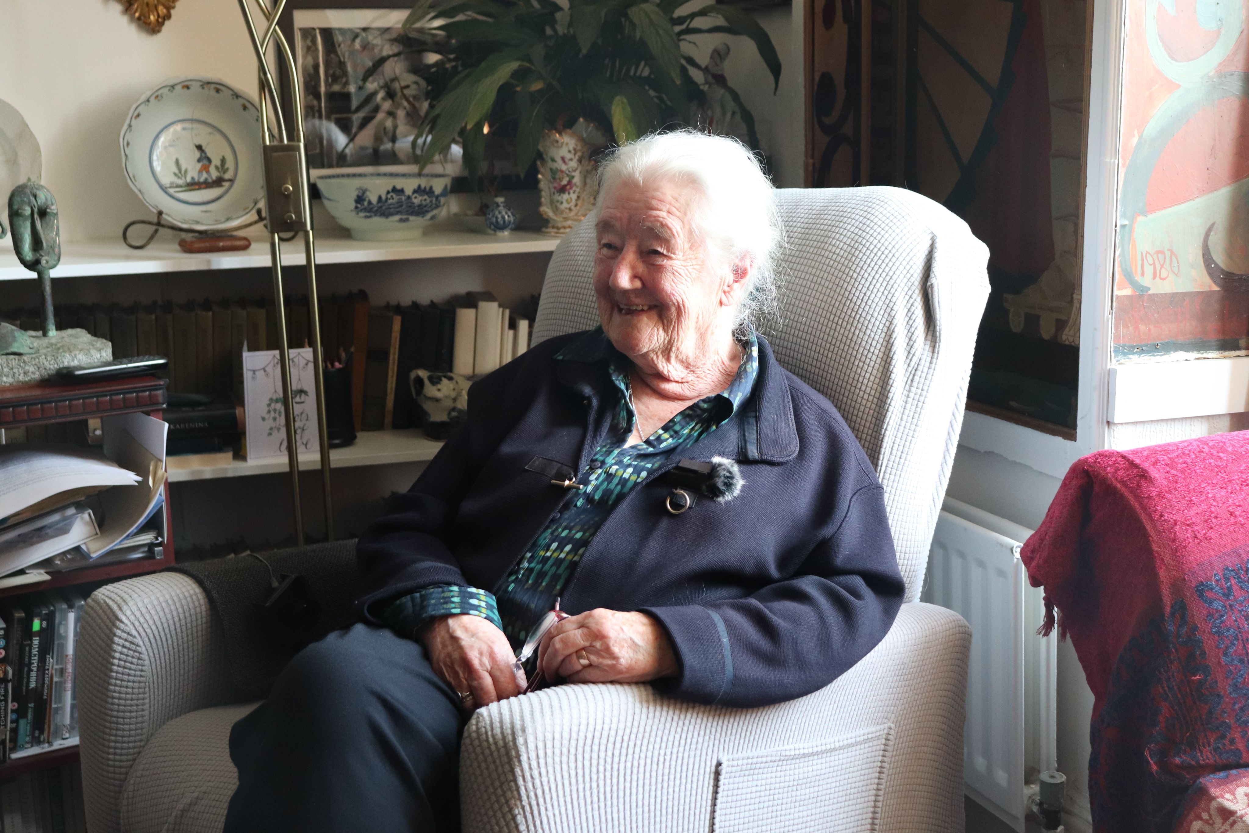 Photograph of a woman sitting on a chair.