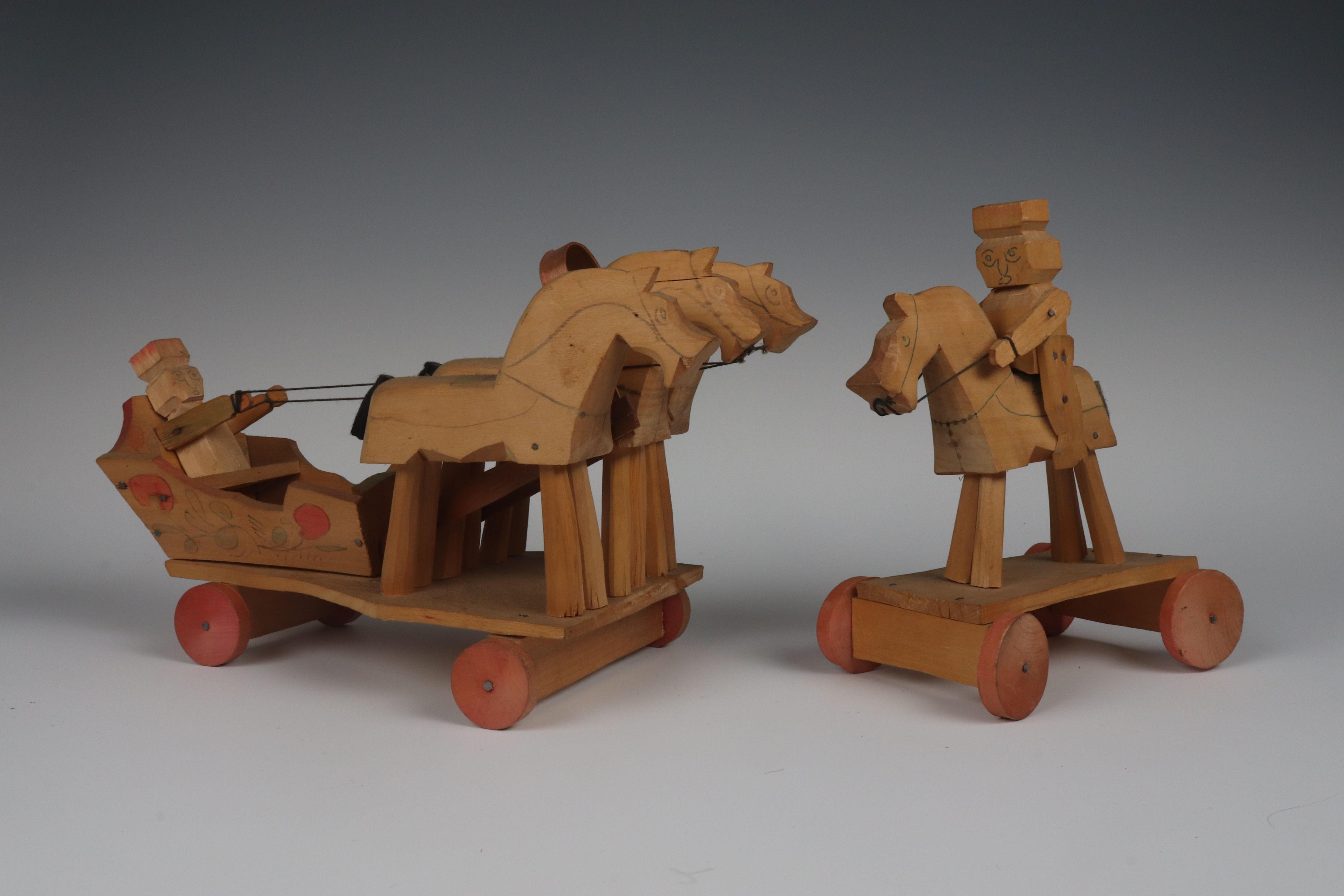 wooden toys on wheels: man on carriage drawn by 3 horses and man on horseback