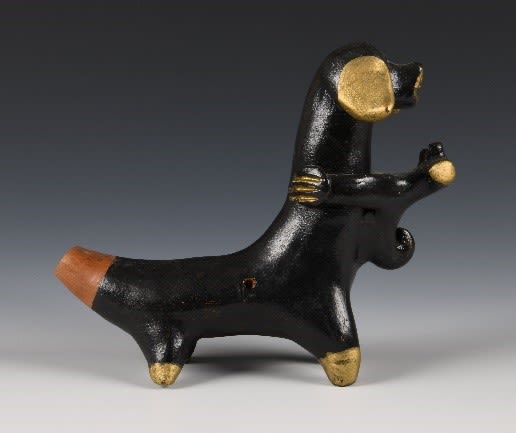 Black clay whistle of a dog and puppy with gold and brown decorations.