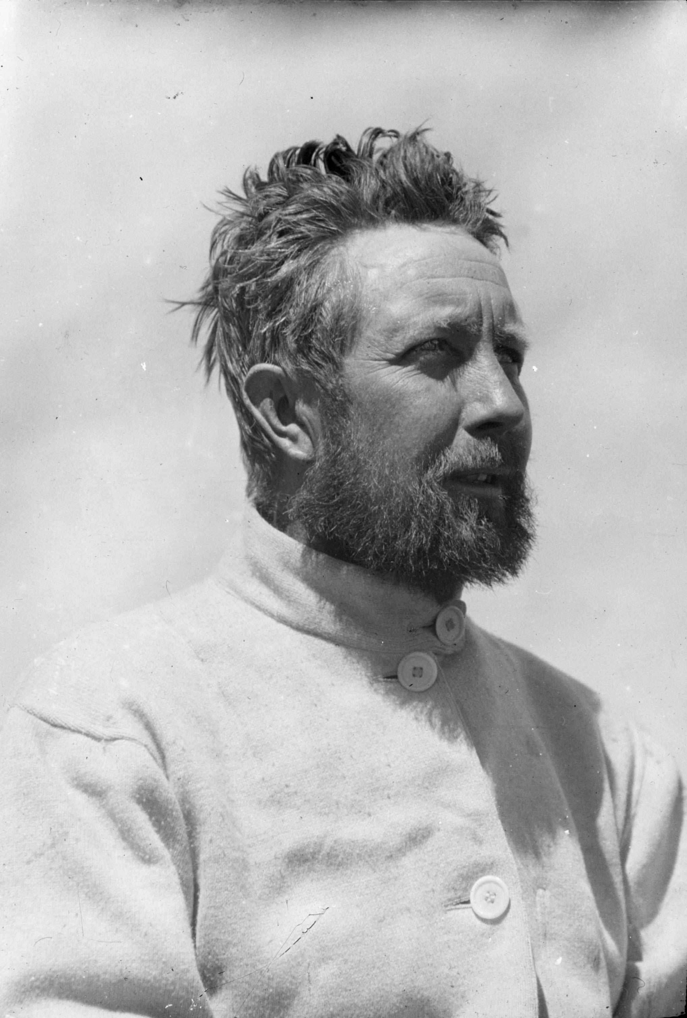 Black and white portrait photo of middle aged white man with dark hair and a beard.