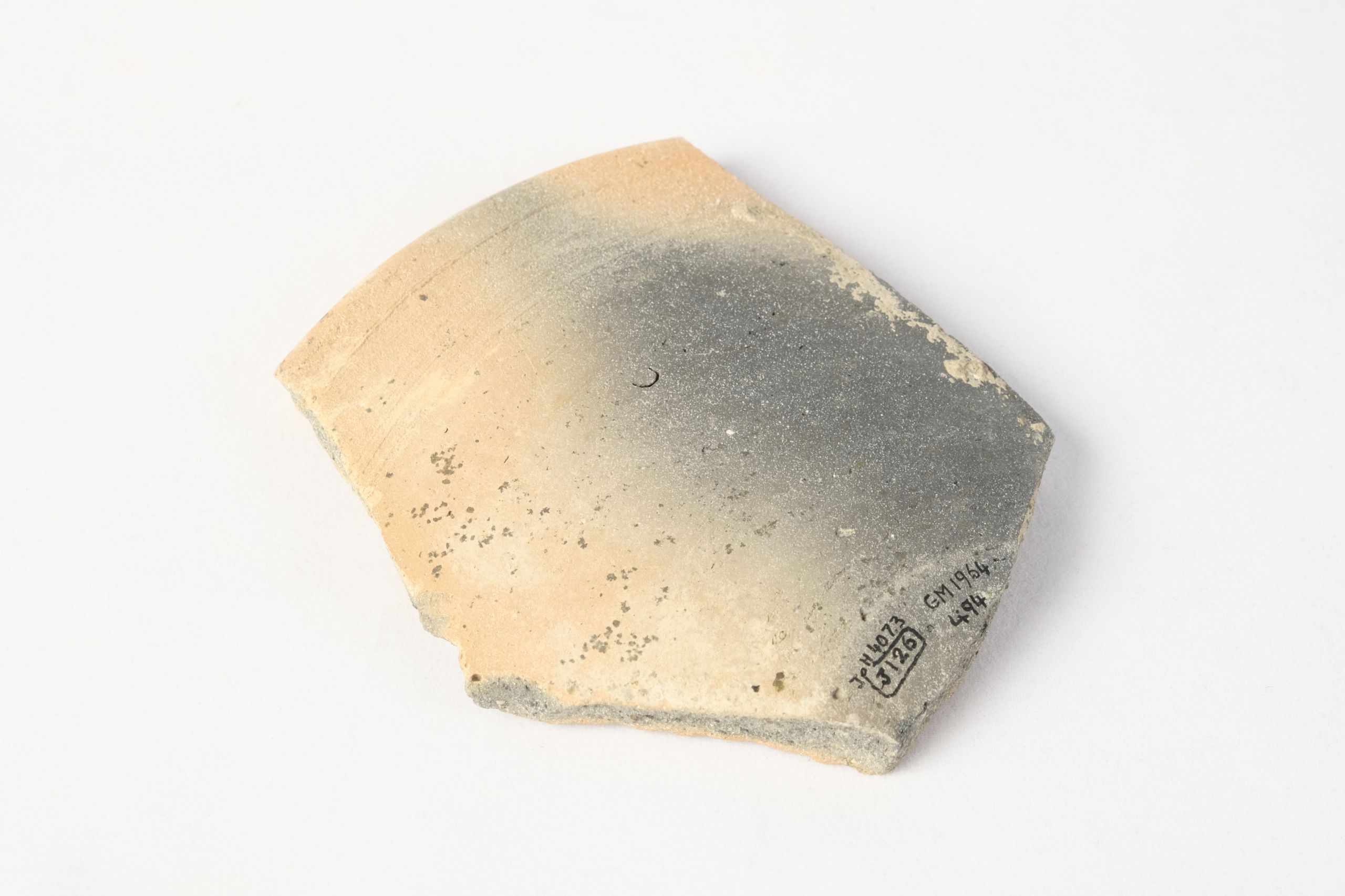 Flat fragment of a bowl, orange and black from burning