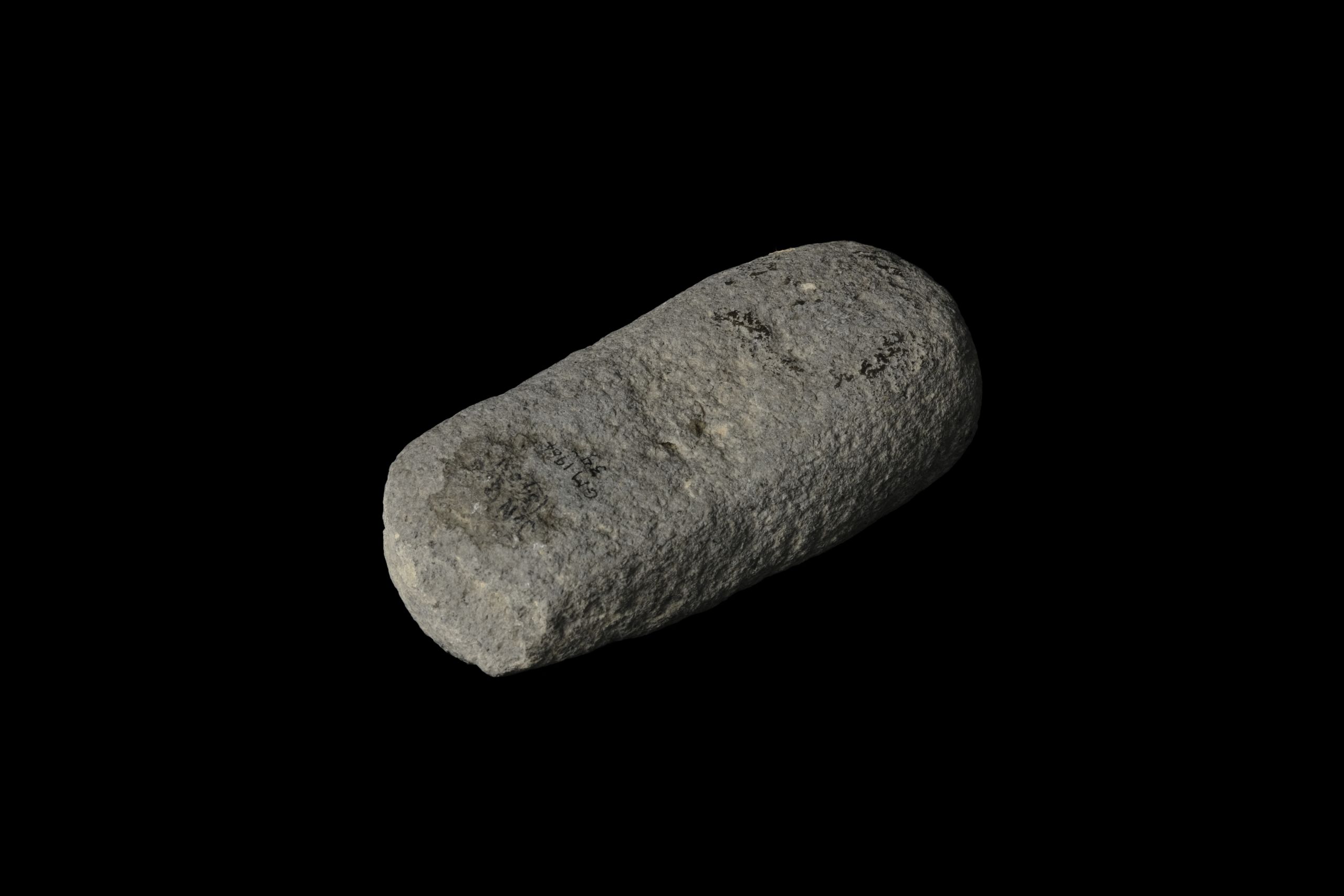 A long grey stone broken on one end and rounded on the other